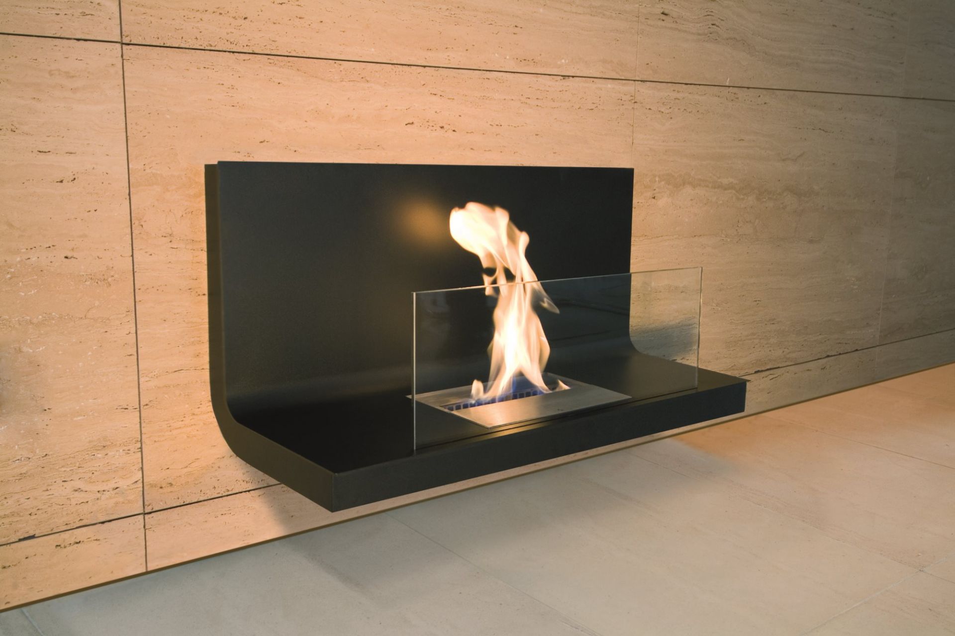 Wall Flame 1 Ethanol Kamin Radius an beiger Wand mit Glasumrandung und brennender Flamme.