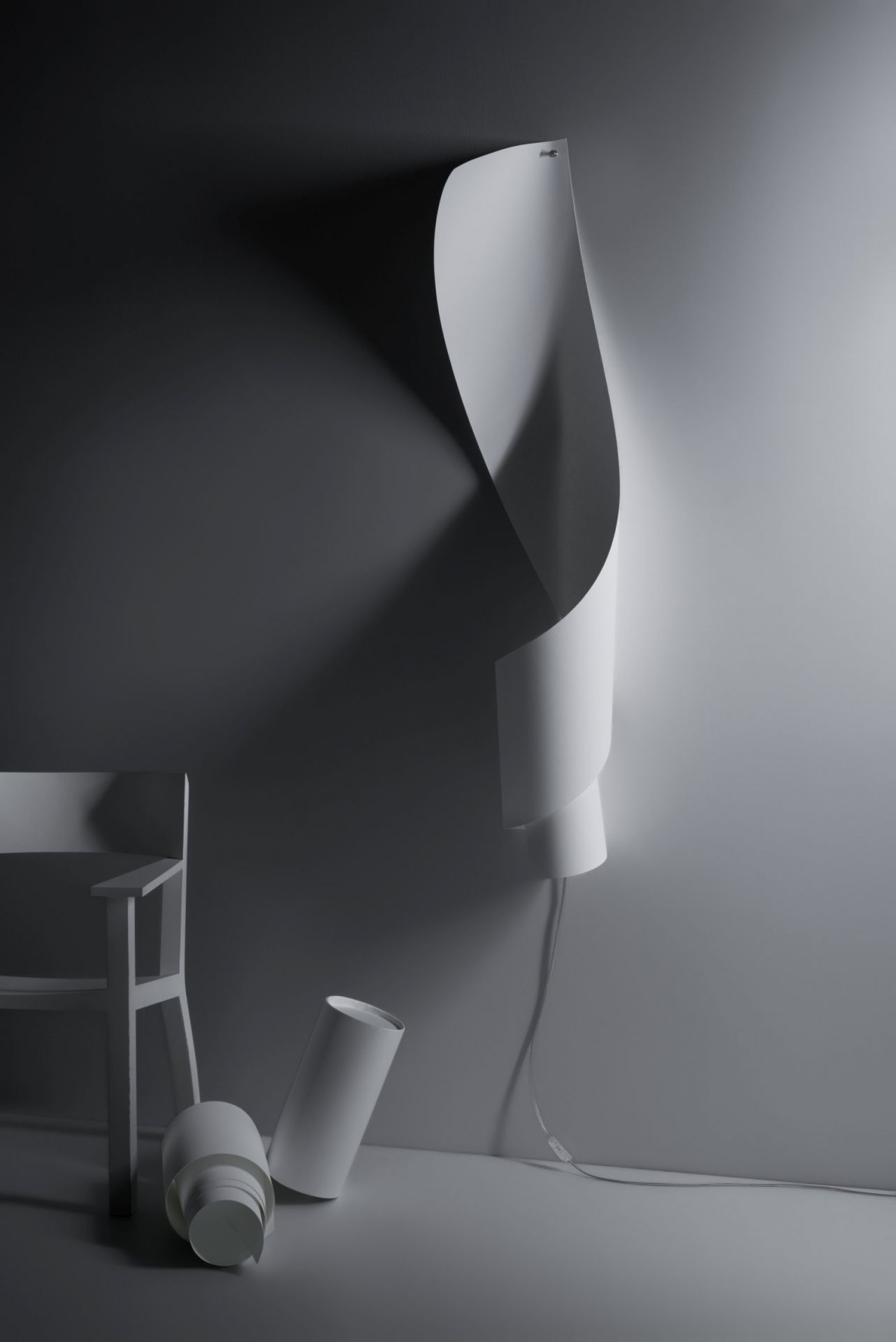 Oop´s Wandleuchte von Ingo Maurer: Geschwungene, weiße Designlampe an der Wand, daneben ein Stuhl.