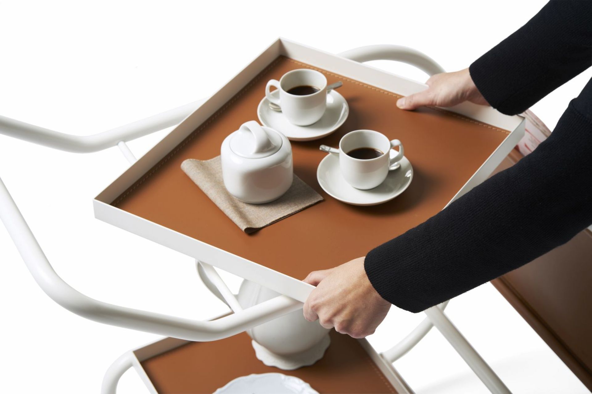 Zenzero Servierwagen von Opinion Ciatti mit Kaffeegeschirr und braunem Leder, gehalten von Händen.