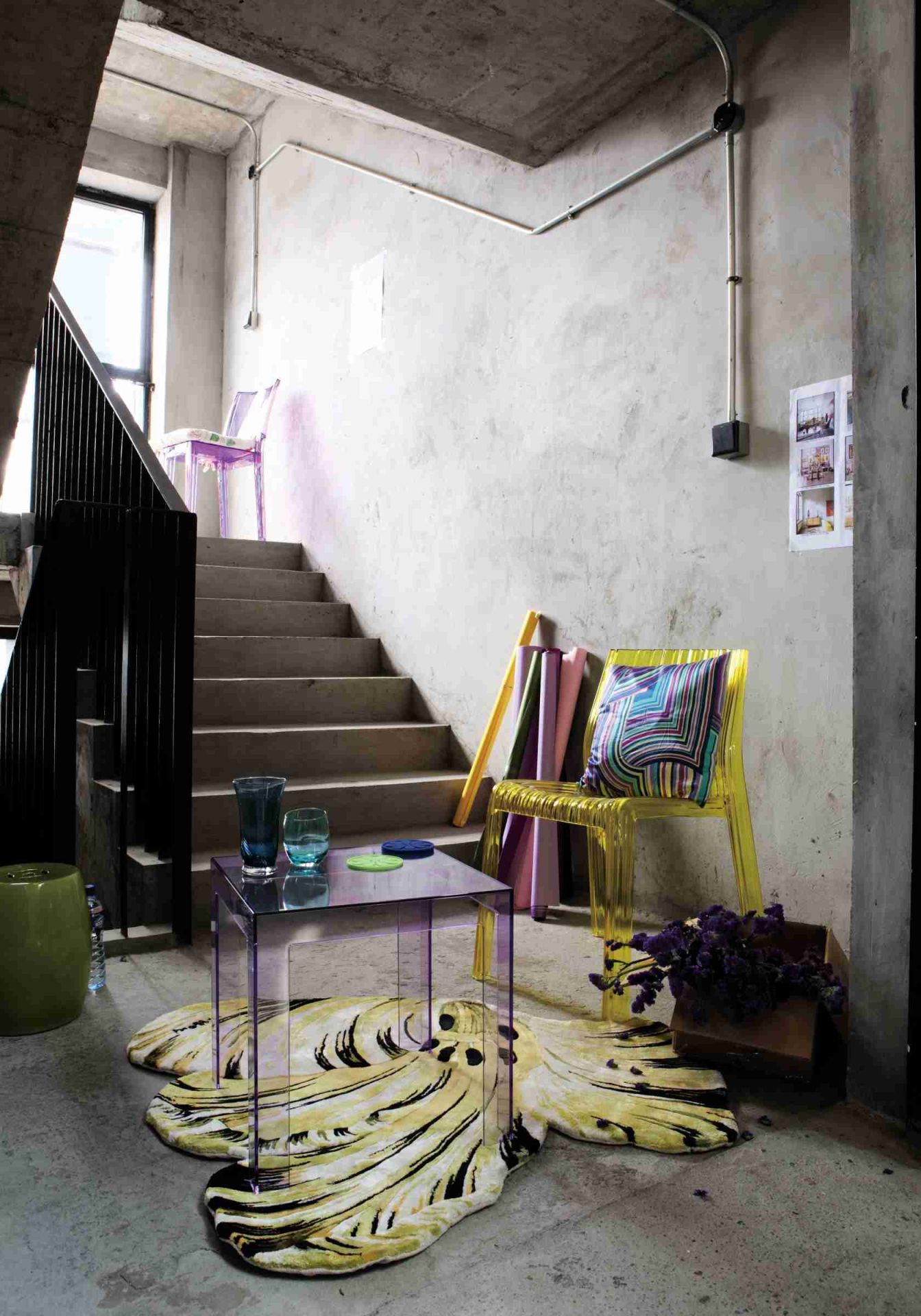 Transparenter Kartell Jolly Beistelltisch aus Acrylglas im modernen Wohnraum mit Treppe und Designelementen.