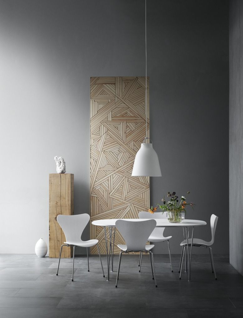 Esszimmer mit Caravaggio Pendelleuchte von Fritz Hansen über einem weißen Tisch und Stühlen.