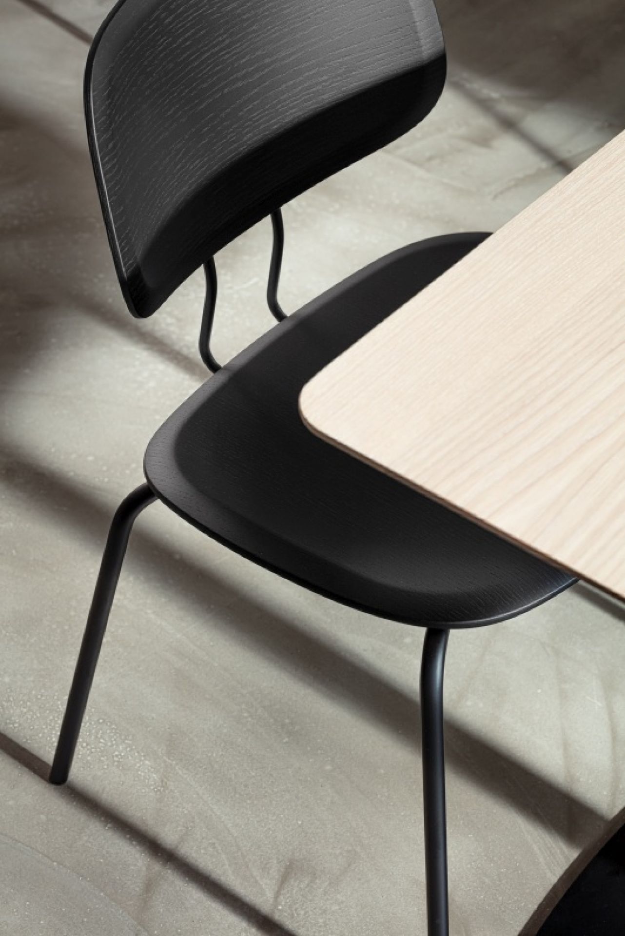 Detailaufnahme vom Vermu Esstisch von Zeitraum mit quadratischer, heller Tischplatte und schwarzem Holzstuhl.