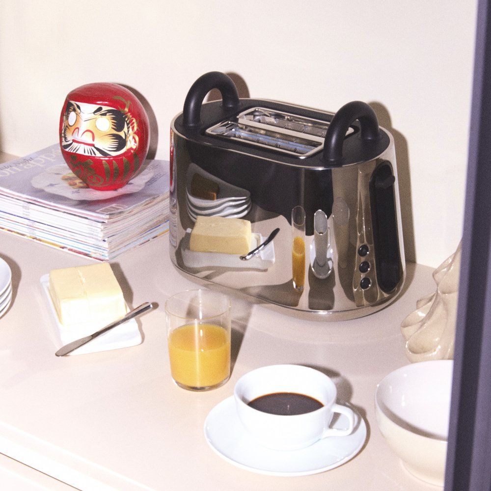 NE03 B Toru Toaster von Alessi, Edelstahl, mit Frühstücks-Szene, Butter, Kaffee und Orangensaft.