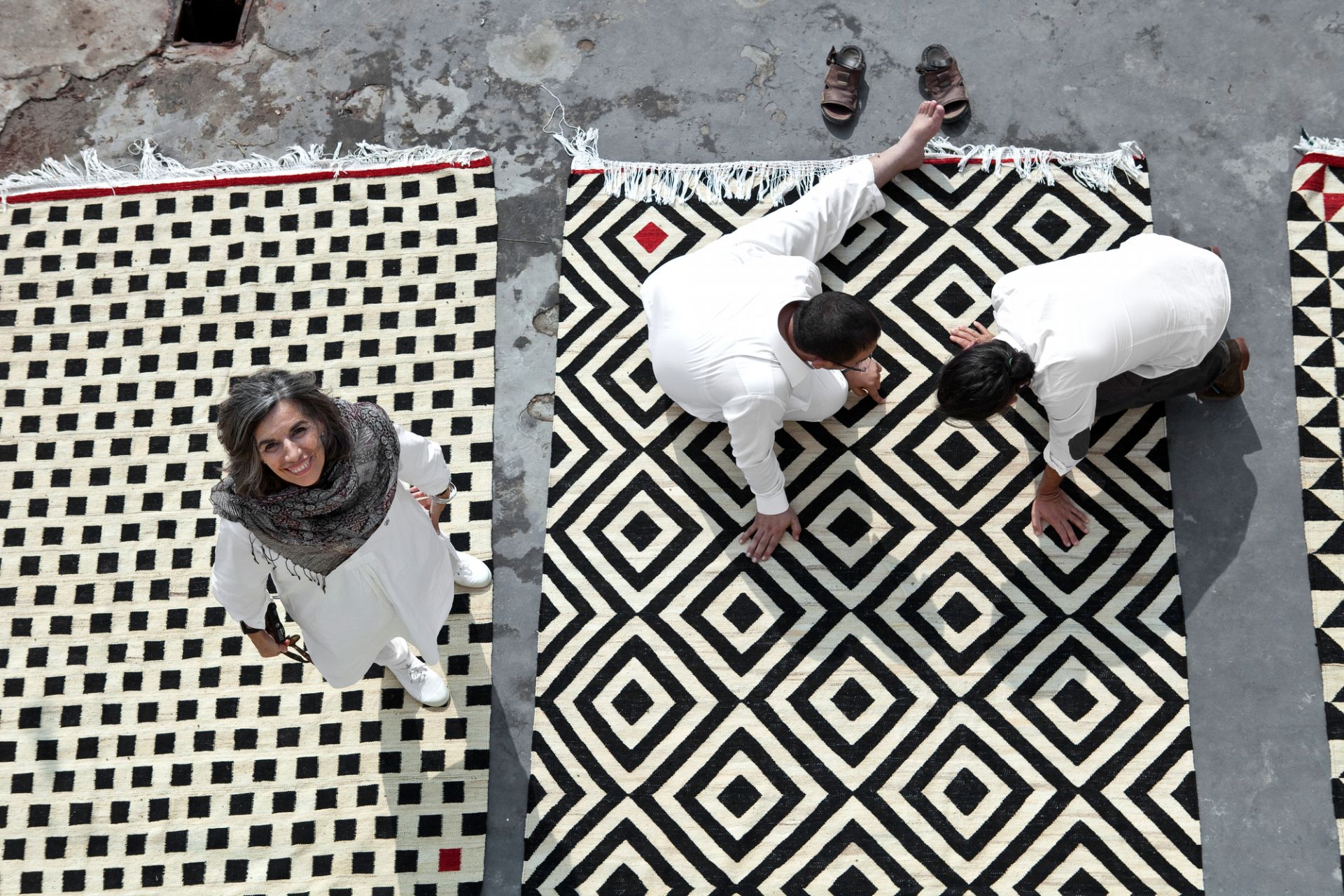 Drei Nanimarquina Teppiche mit geometrischen Mustern. Mélange Pattern Teppich in Schwarz-Weiß mit Personen.