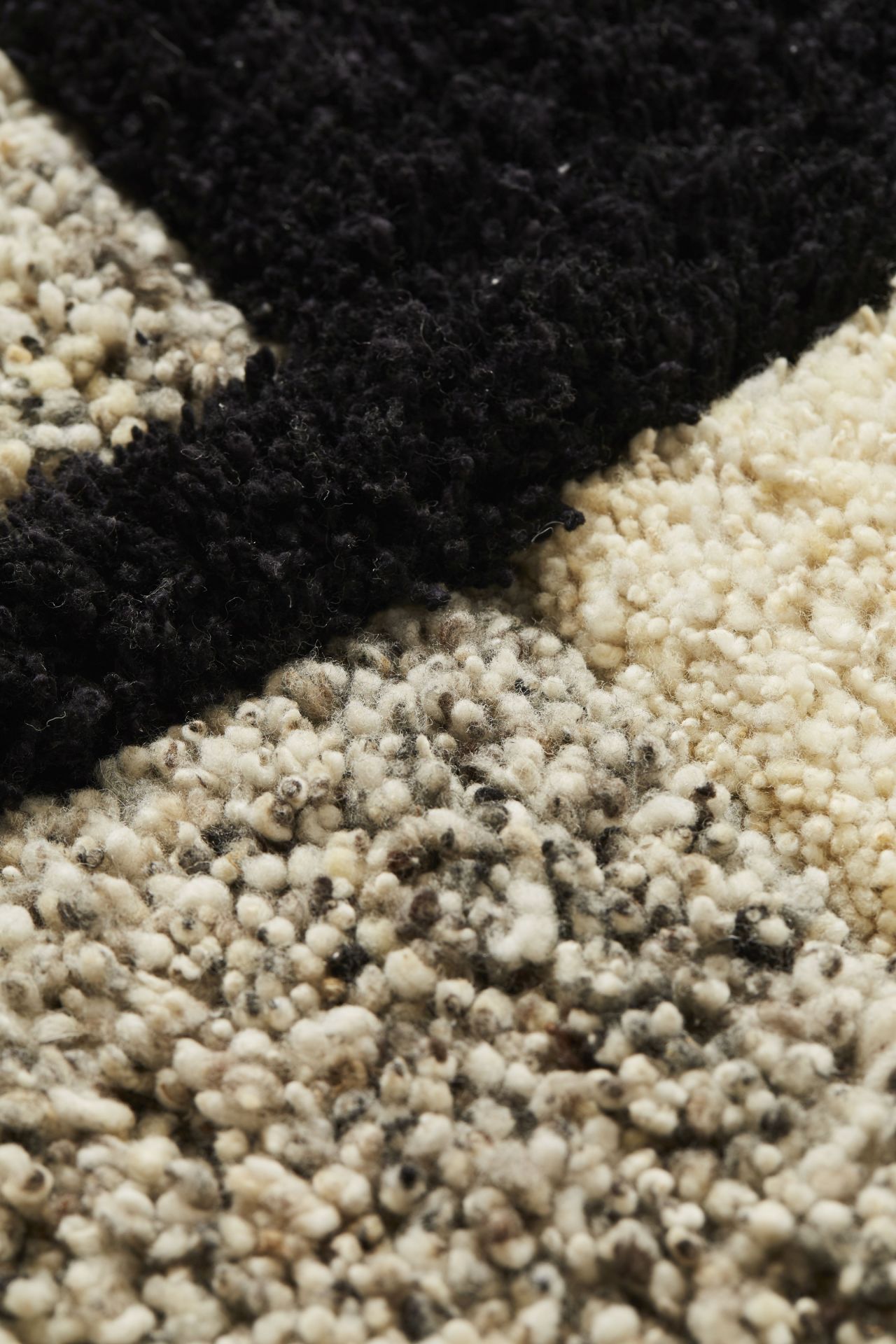 Detailaufnahme des Nudo Teppichs von ames, groß, mit schwarzem und cremefarbenem Muster.