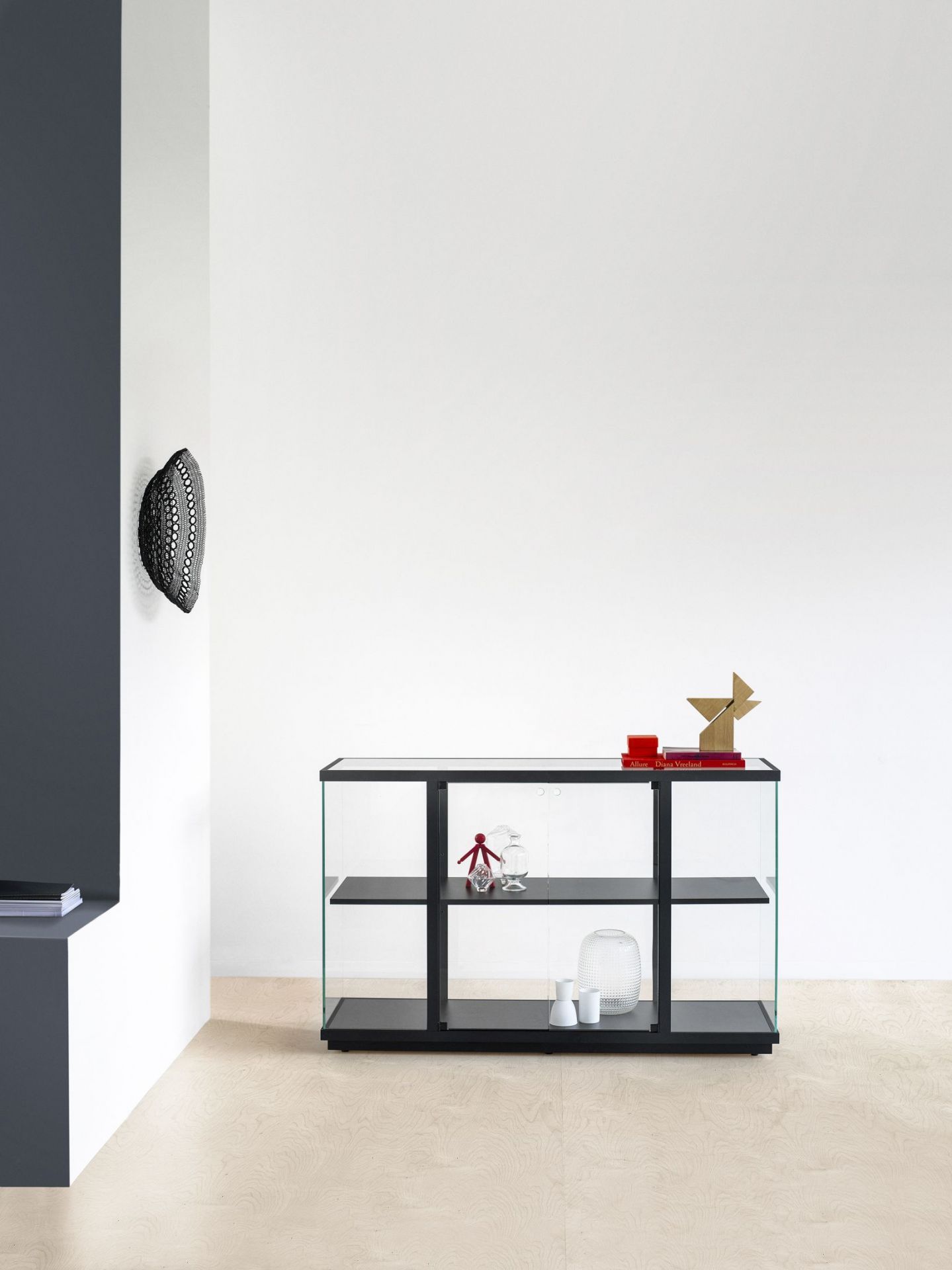 Schwarze Stolp Vitrine mit Glasseiten und drei Regalböden, ideal für Wohnzimmer oder Esszimmer.