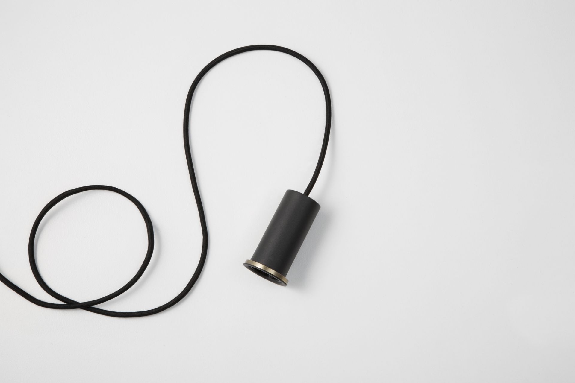 Schwarze Collect Pendelleuchte von Ferm Living mit Textilkabel auf weißem Hintergrund. Moderne Hängelampe.