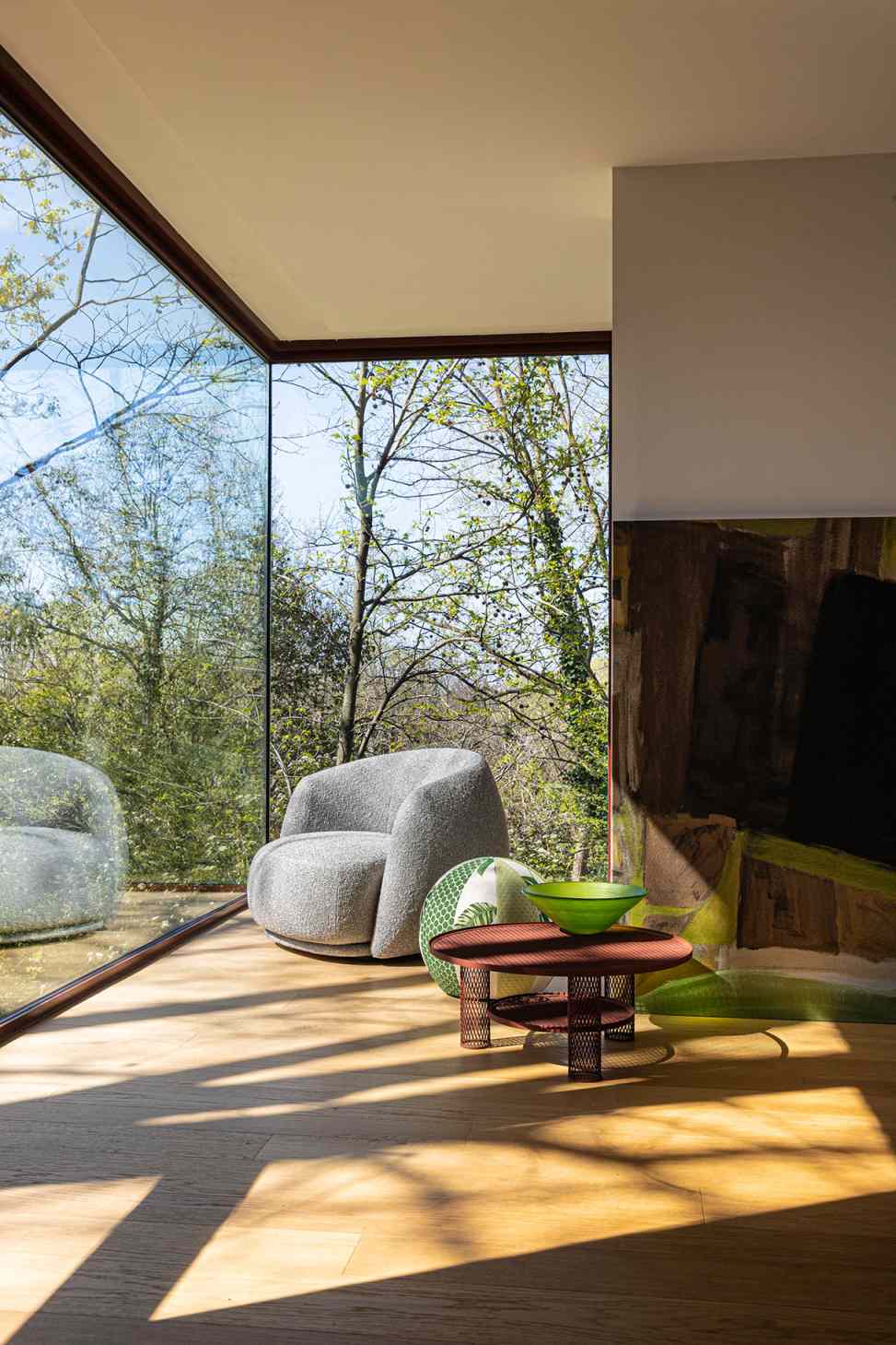 Grauer Pacific Armchair Sessel von Moroso in modernem Wohnzimmer mit großem Fenster.