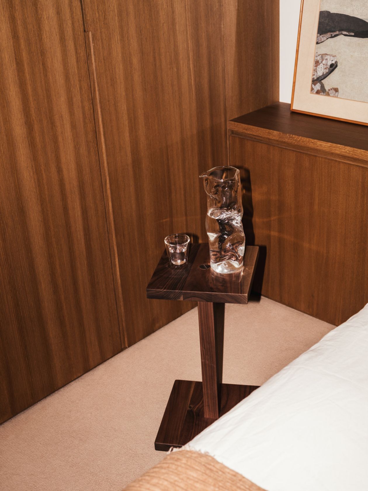 Peana Molina Beistelltisch von Santa & Cole aus dunklem Holz mit Wasserkanne und Glas.