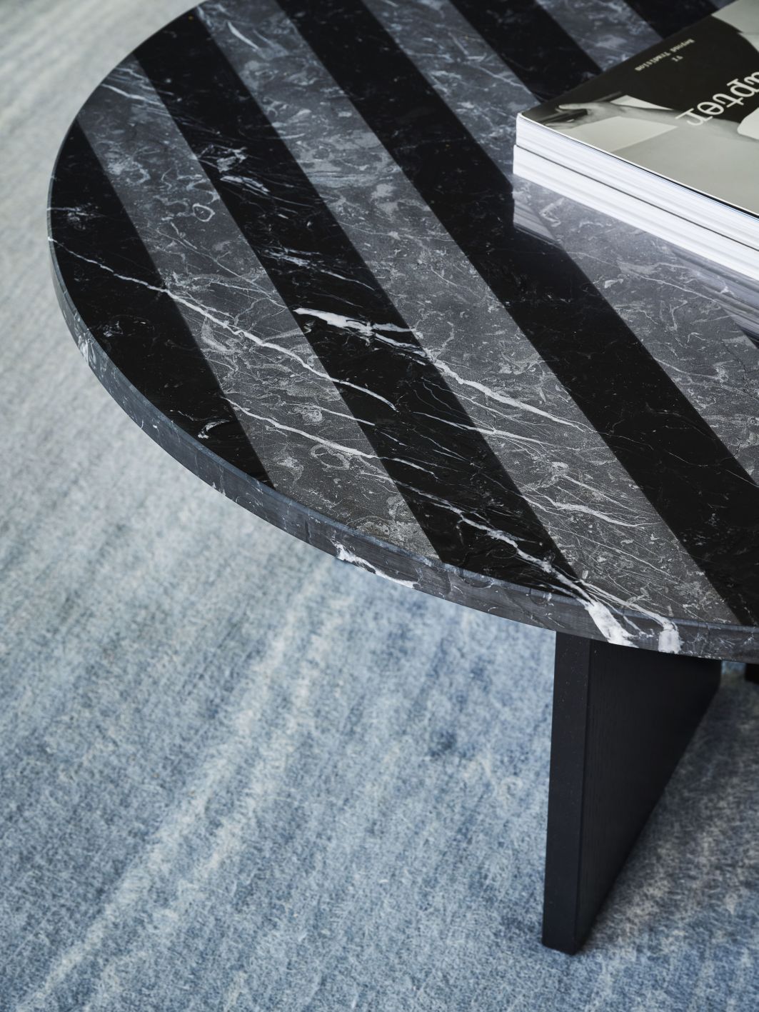 Nahaufnahme des runden Sediment Coffee Table Couchtisch Nero Marquina mit schwarzem Marmor und Zeitschriften.