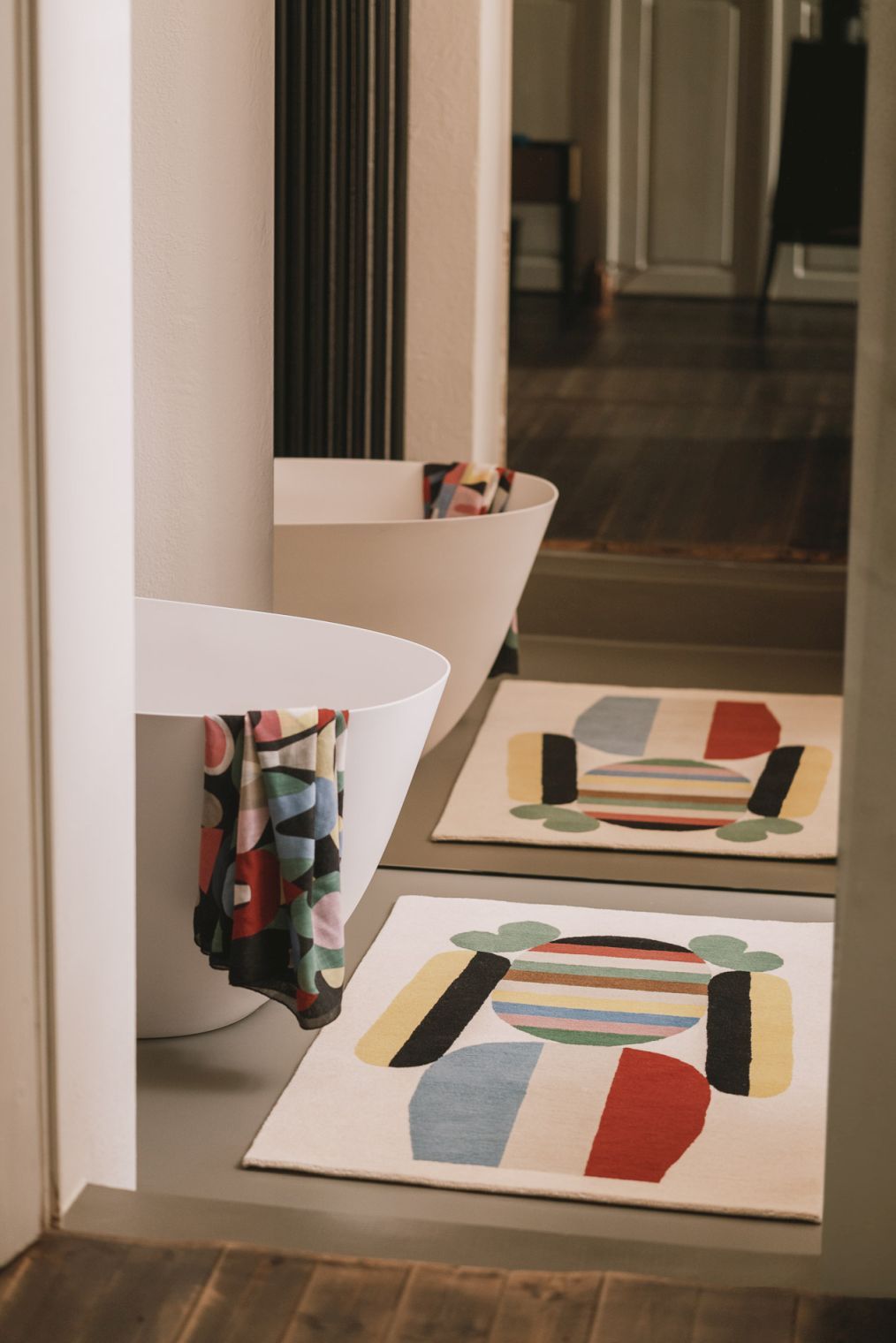 Zwei Bela Teppiche von Designercarpets mit abstraktem Muster in einem modernen Badezimmer.