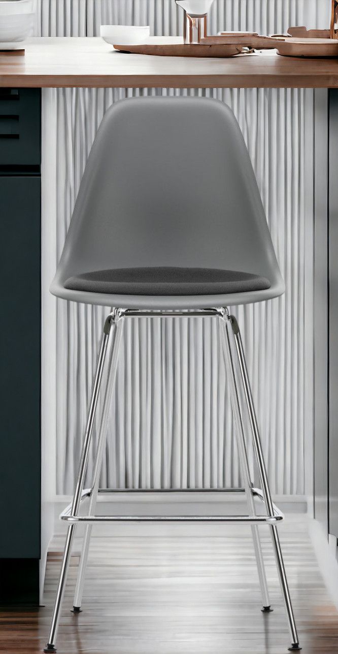 Grauer Eames Plastic Bar Stool Barhocker Medium von Vitra mit Sitzpolster und Chromgestell.