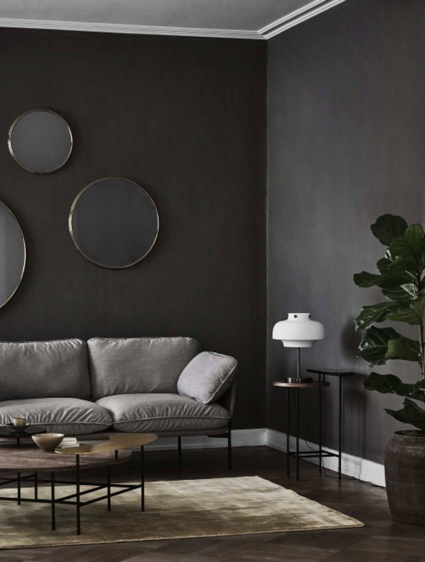 AndTradition Palette Table JH25 Couchtisch im Wohnzimmer mit Sofa, Lampe und runden Spiegeln.