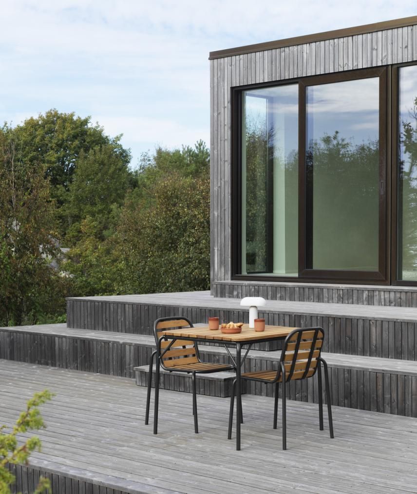 Normann Copenhagen Vig Table 90x90 cm Outdoor Tisch mit zwei Stühlen auf Holzterrasse.
