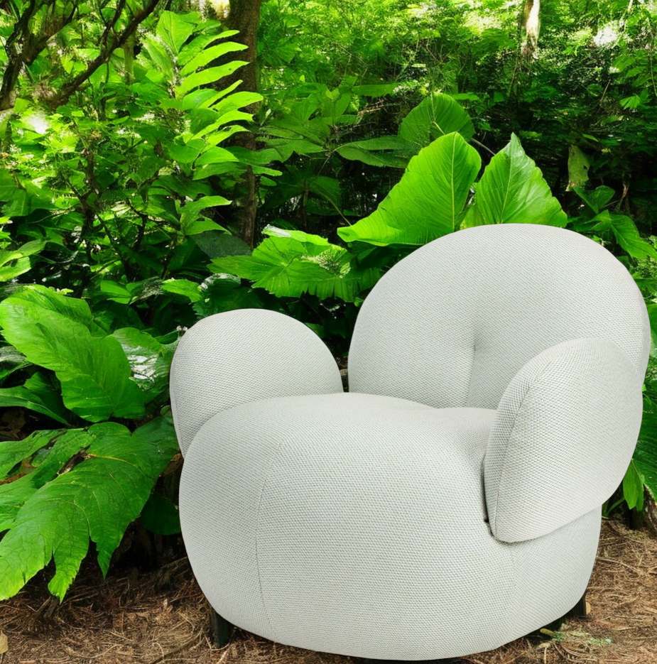 Nana Outdoor Sessel von Freifrau Manufaktur in hellem Stoff vor grünem Hintergrund. Gartenmöbel.