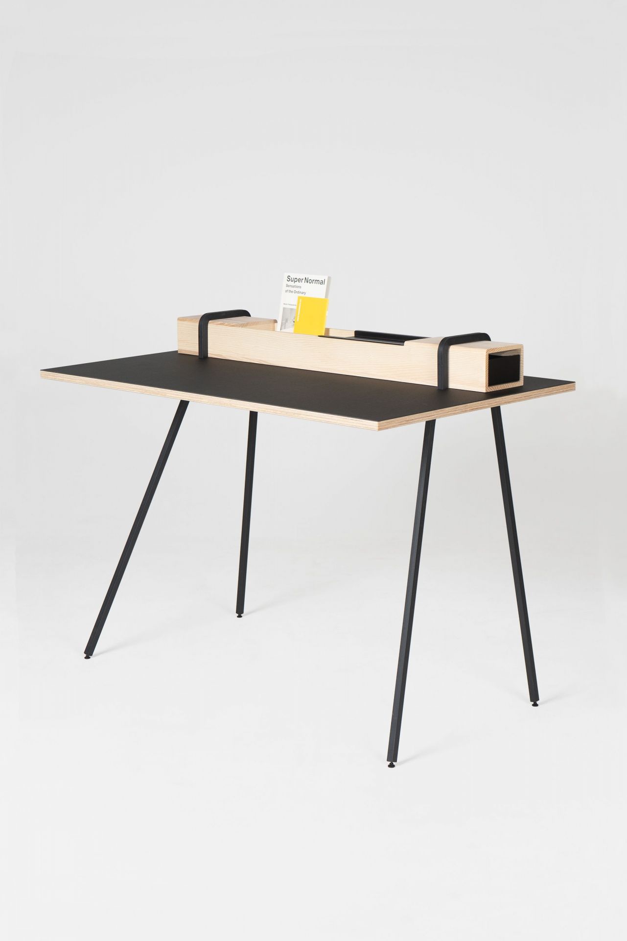 Kurt Sekretär von Nils Holger Moormann: Moderner Schreibtisch mit schwarzer Arbeitsfläche und Ablagefach.