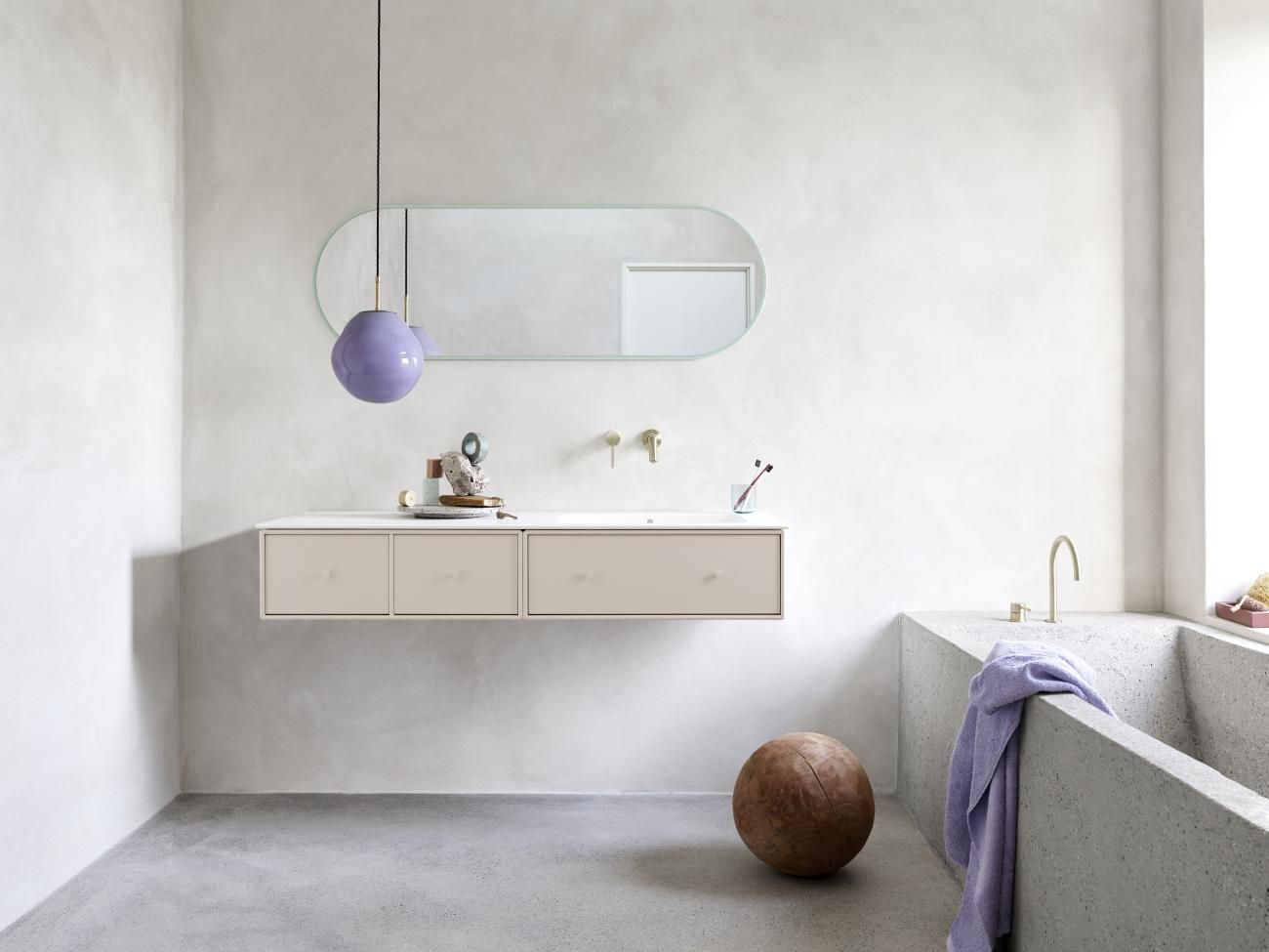 Badezimmer mit Montana Spiegel, Waschtisch, Badewanne und lila Lampe. Moderner Spiegel für stilvolles Badezimmerdesign.
