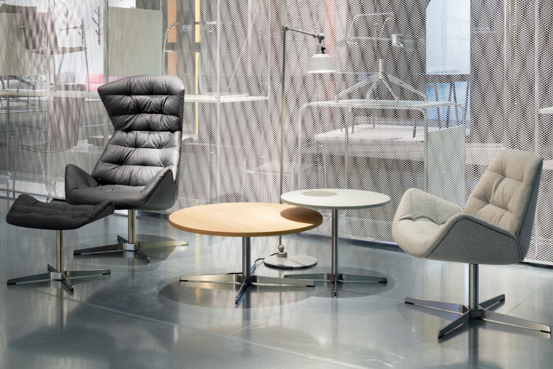 1808 Thonet Beistelltisch aus Holz mit Metallfuß neben Sesseln und Stehlampe.