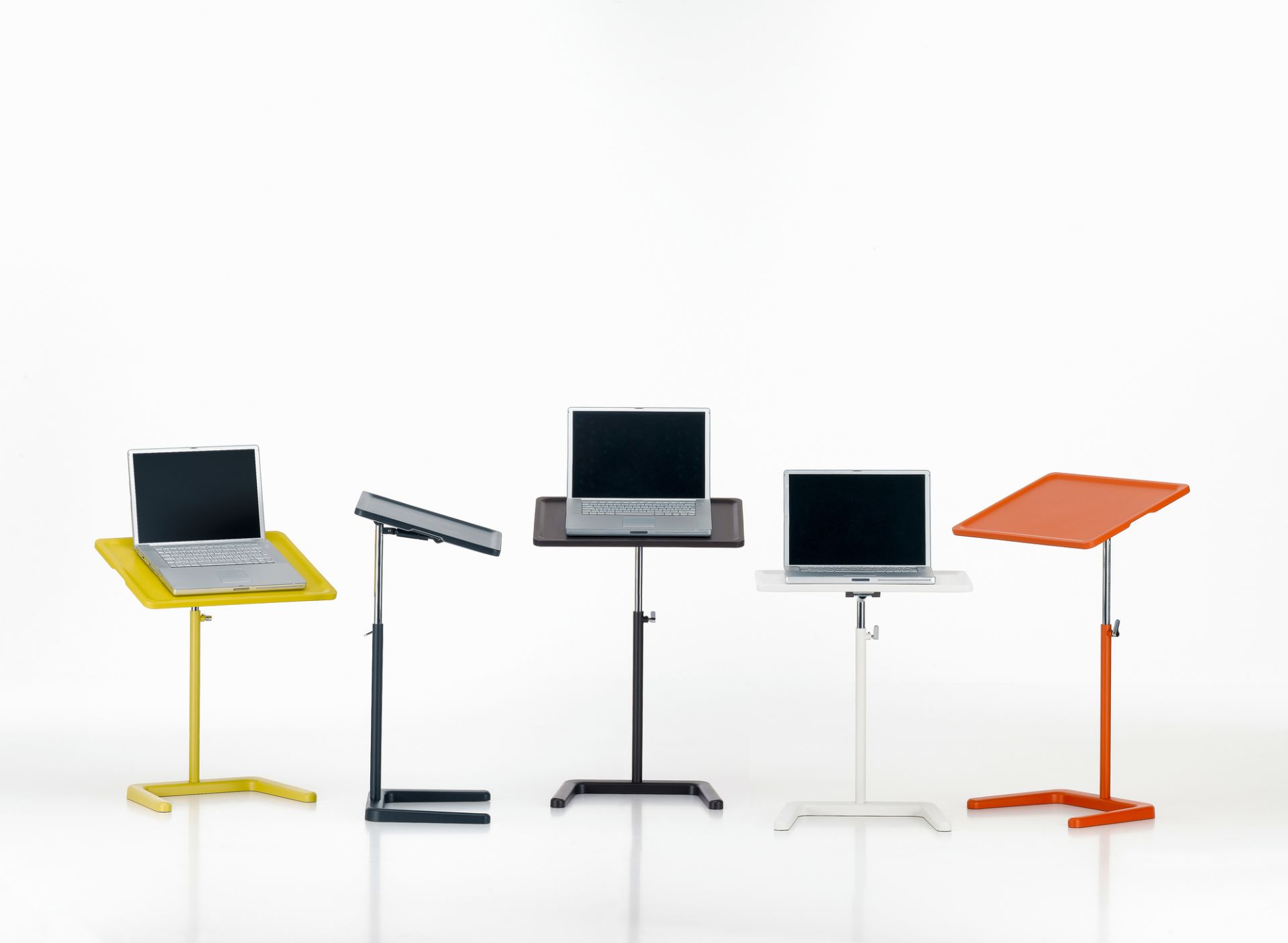 Verschiedene farbige Nes Table Beistelltische von Vitra, höhenverstellbar, mit Laptops darauf.