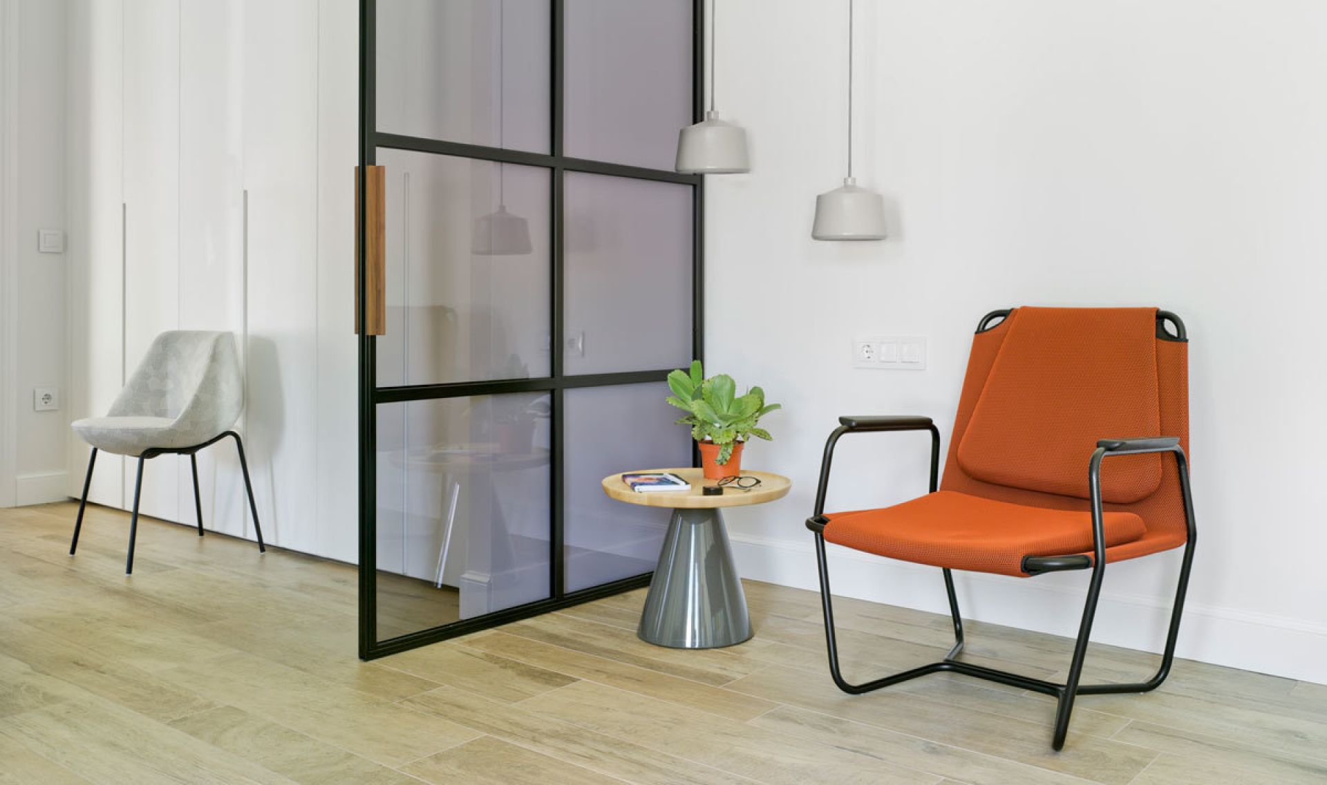 Pion Beistelltisch von Sancal neben Sessel und Pflanze im modernen Wohnzimmer. Kleiner Tisch.