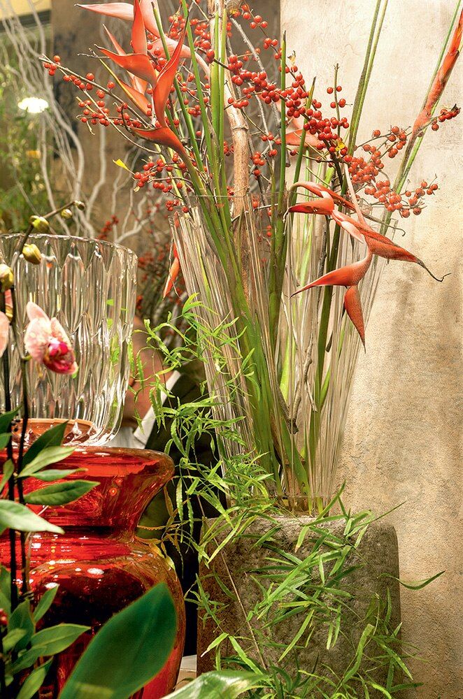 Transparente Shanghai Vase von Kartell mit floralem Arrangement aus roten Blüten und Beeren.