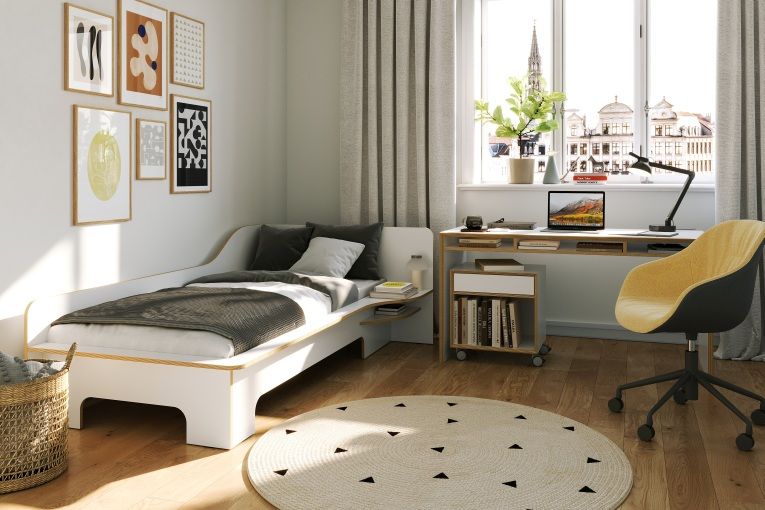 Heller Raum mit Bridge Schreibtisch von Müller Möbelwerkstätten, Bett, Teppich und gelbem Bürostuhl.