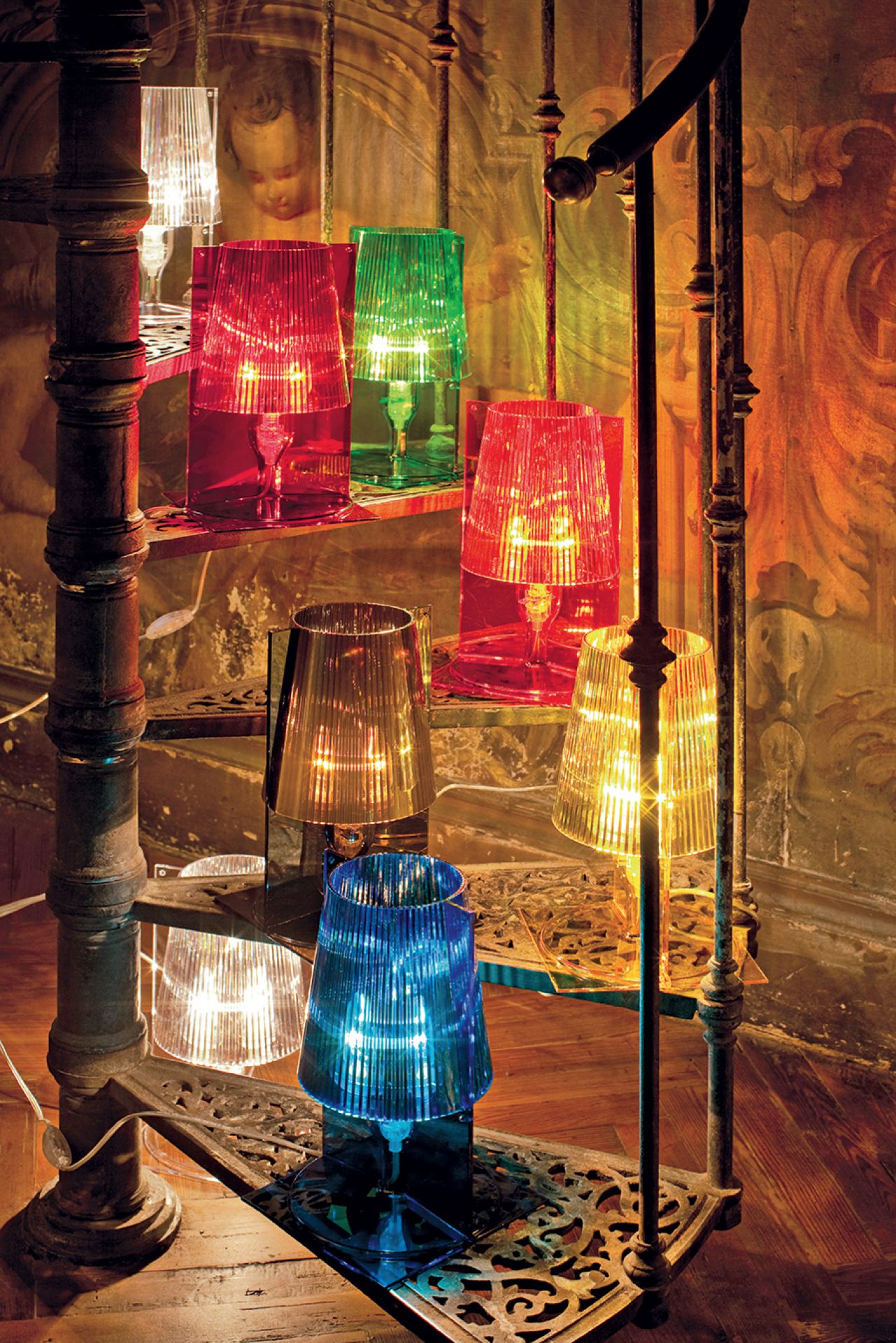 Bunte Take Tischleuchten von Kartell auf einer Treppe, die warmes Licht ausstrahlen und stilvolle Akzente setzen.