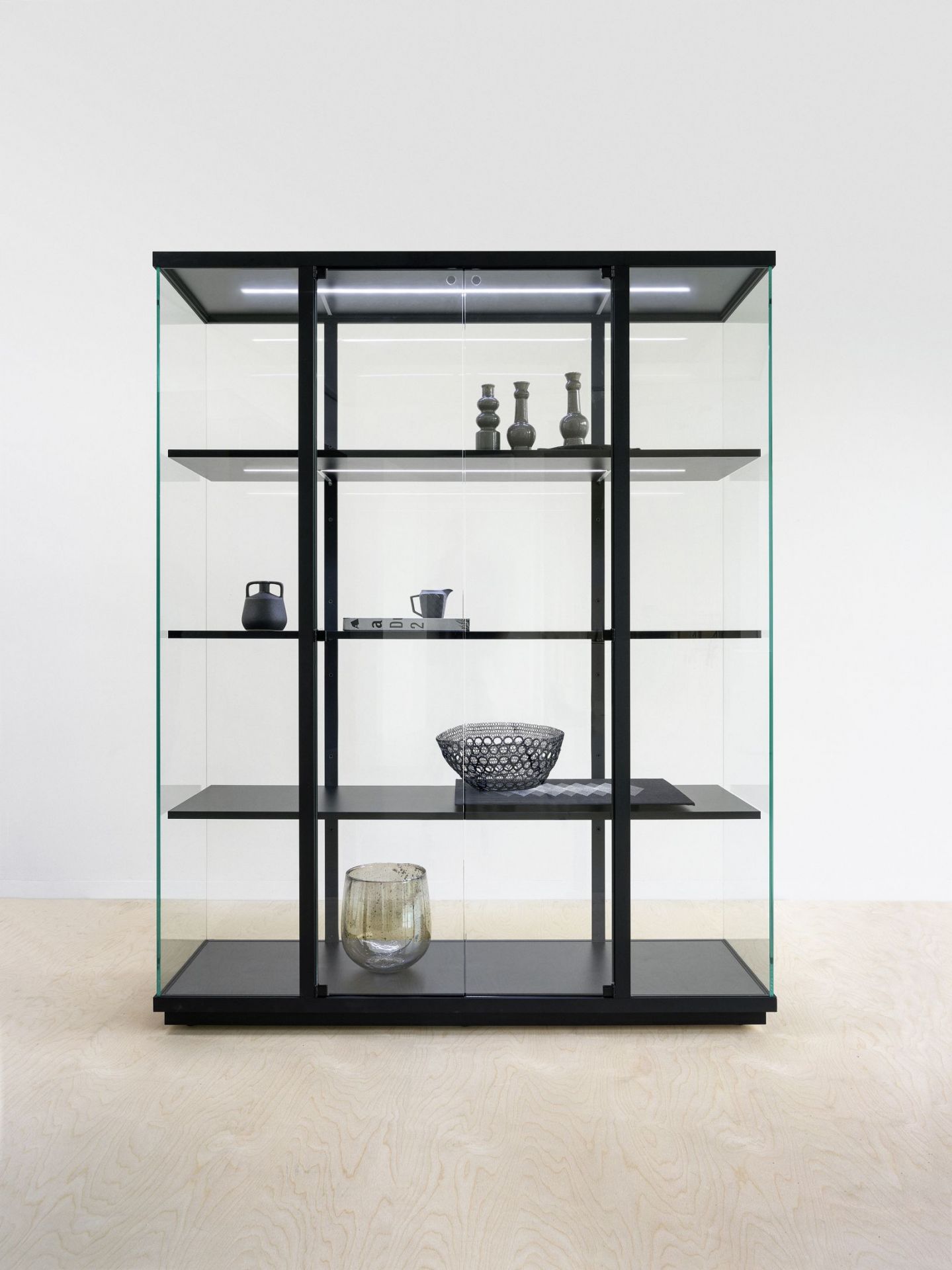 Schwarze Stolp Vitrine mit Glasfronten und LED-Beleuchtung, ideal für Wohnzimmer und Esszimmer.