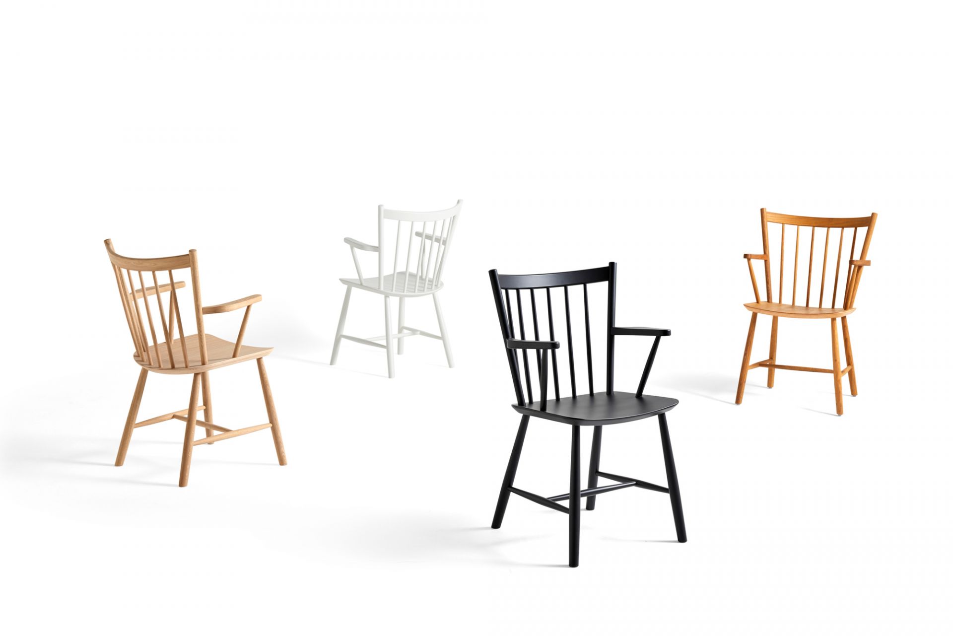 Vier J42 Stühle von Hay in Holz, Weiß, Schwarz und Eiche auf weißem Hintergrund.