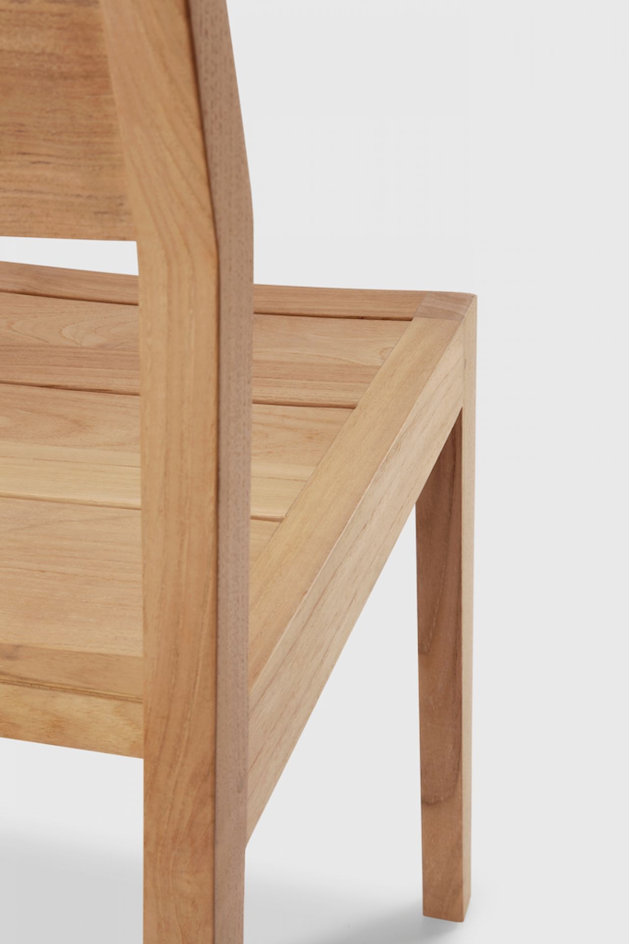 Detailaufnahme des Ethnicraft EX 1 Outdoor Stuhls aus Teakholz, Fokus auf Sitzfläche und Bein.