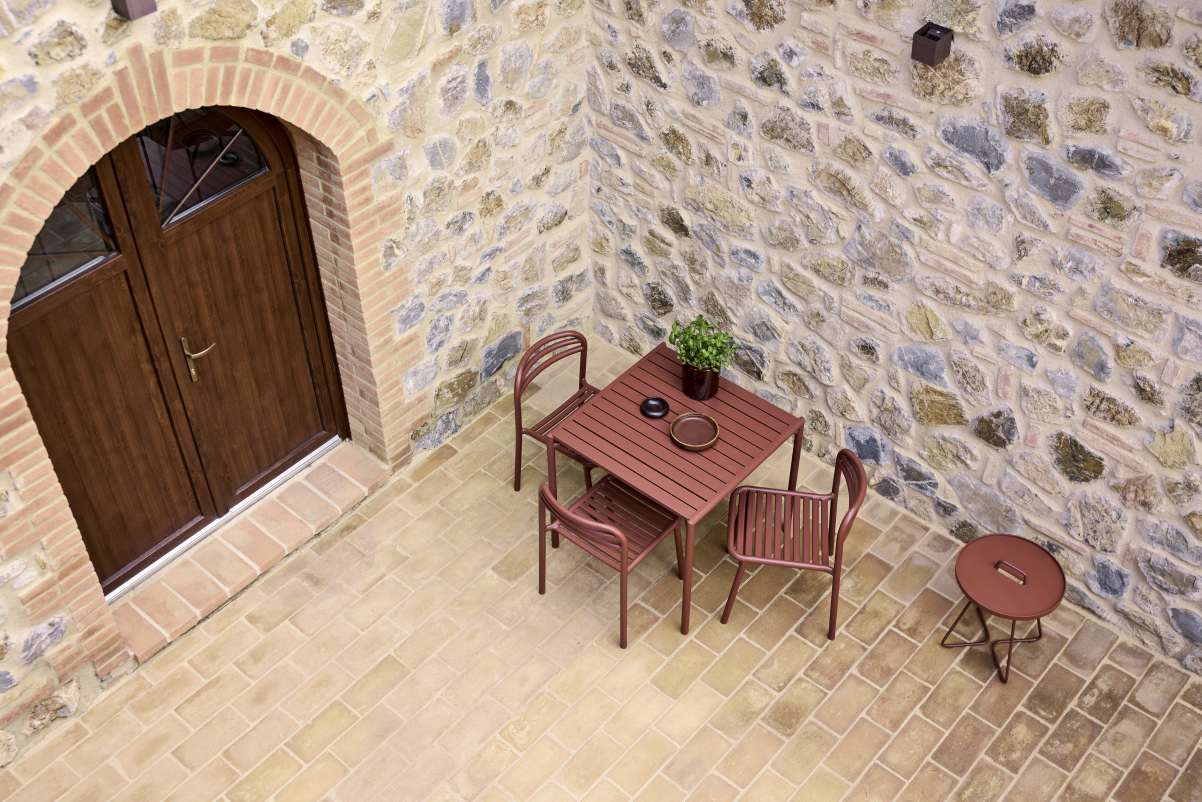 Bliss Esstisch Desert-Sand von Cane Line für den Außenbereich mit Stühlen und Beistelltisch.