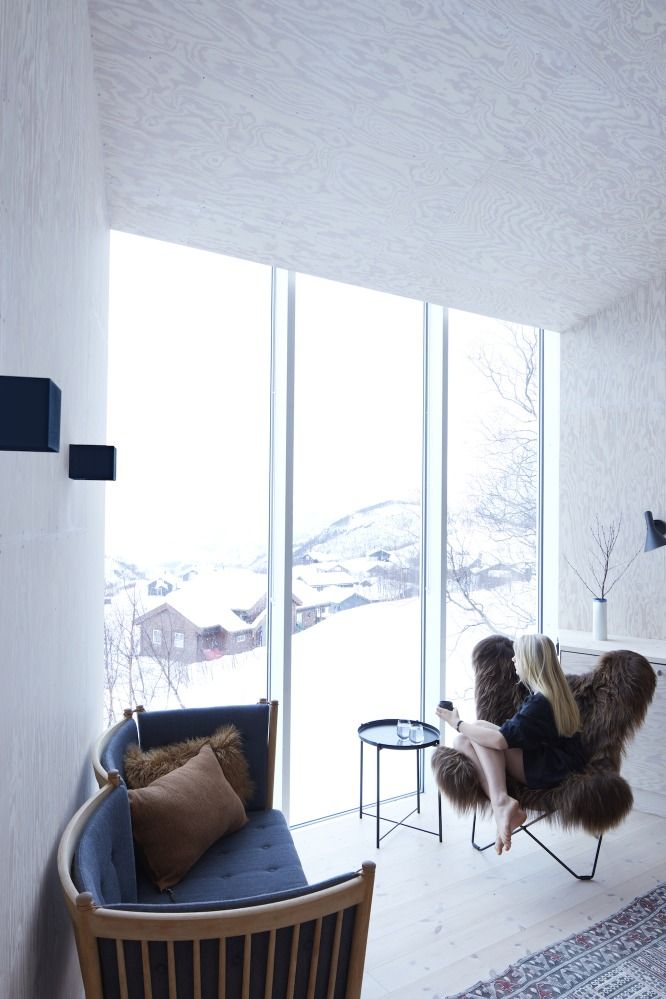 Frau sitzt im Iceland Mariposa Sessel mit Schaffell in modernem Interieur. Design Sessel.