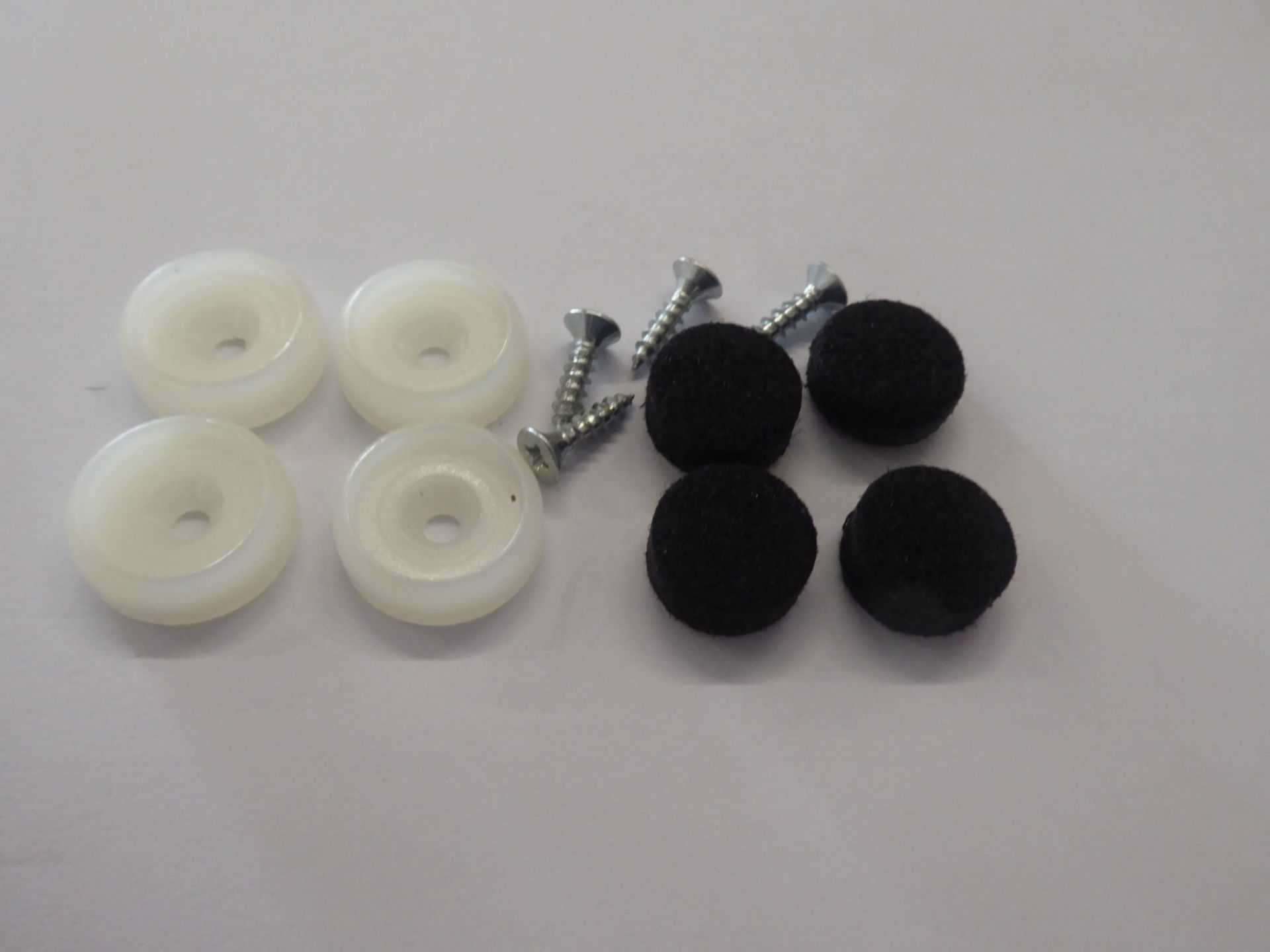 Filzgleiter Set für Eames Chair: Weiße Gleiter, Schrauben und schwarze Filz Pads.