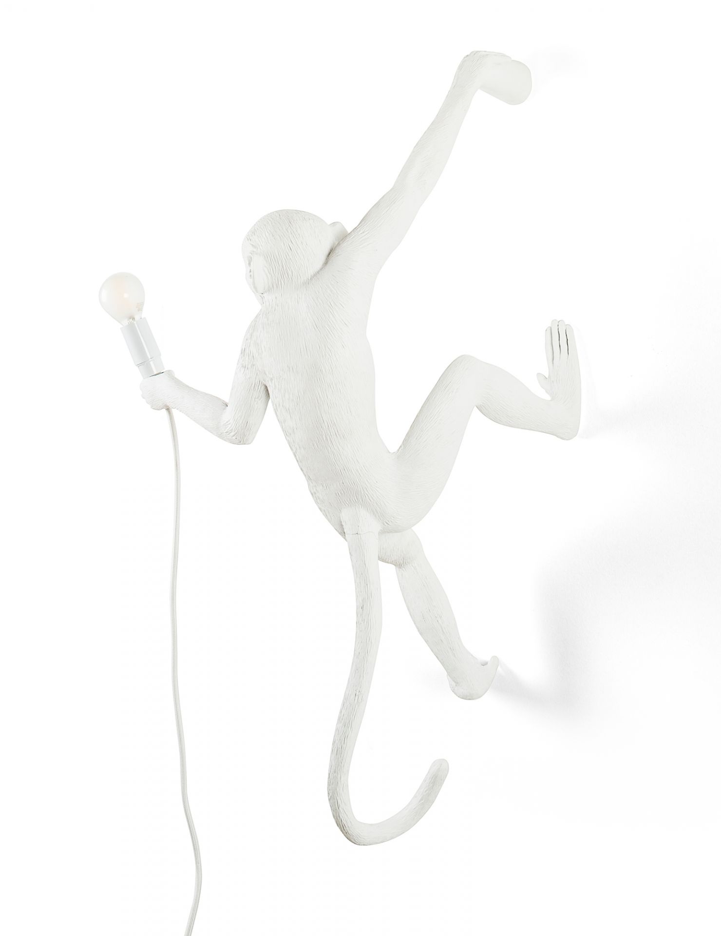 Weiße Monkey Lamp Wandleuchte (rechts) von Seletti mit Lampe in der Hand. Design Lampe.