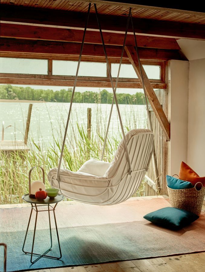 Leyasol Lounge Schwingsessel von Freifrau Manufaktur vor Fenster mit Seeblick. Hängesessel für entspannte Momente.
