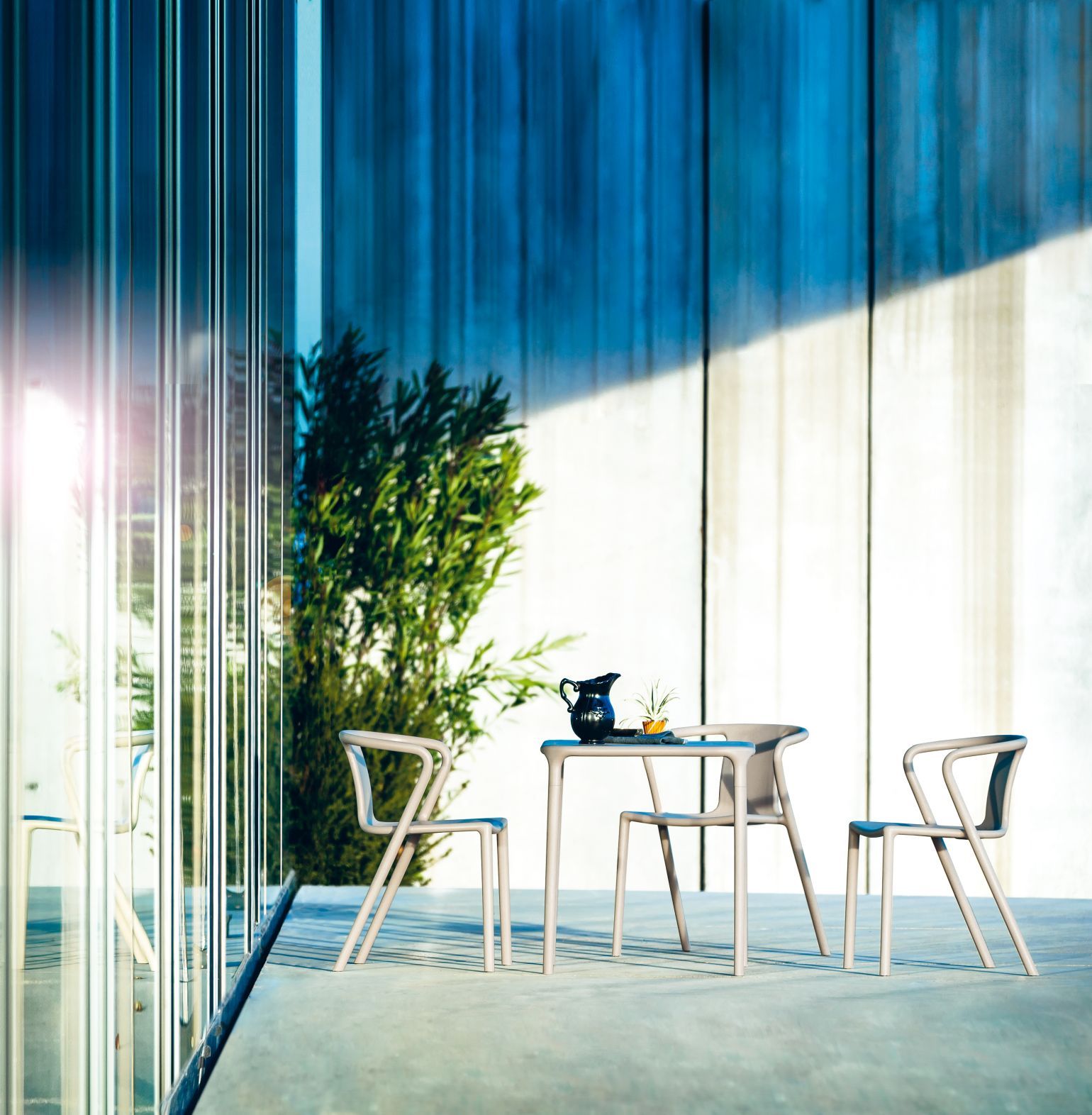 Air Table Magis: Modernes Outdoor-Set mit Tisch und Stühlen in Beige auf Terrasse.