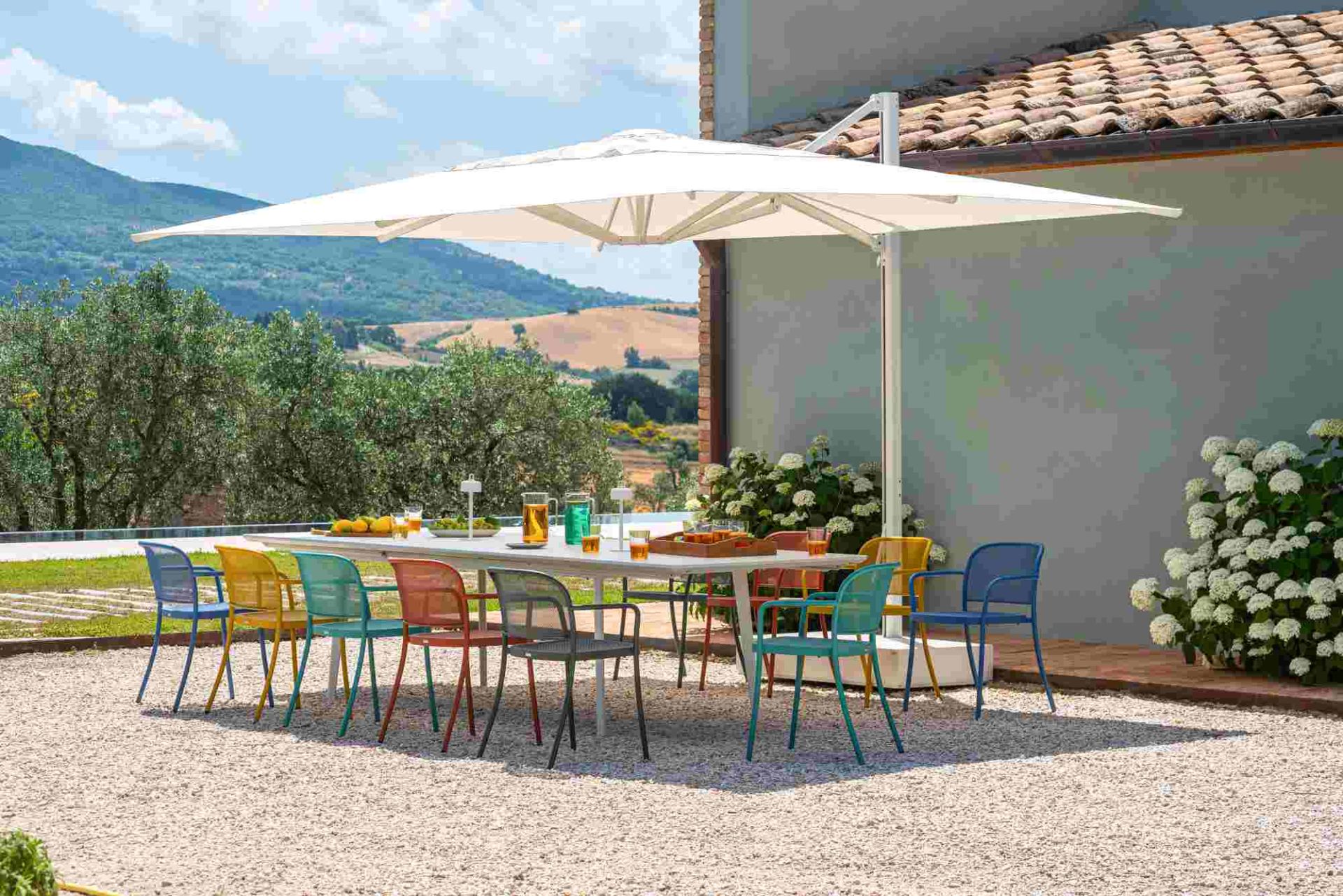 Café Armchair von Emu: Bunte Armlehnstühle aus Metall für den Outdoor-Bereich auf einer Terrasse.