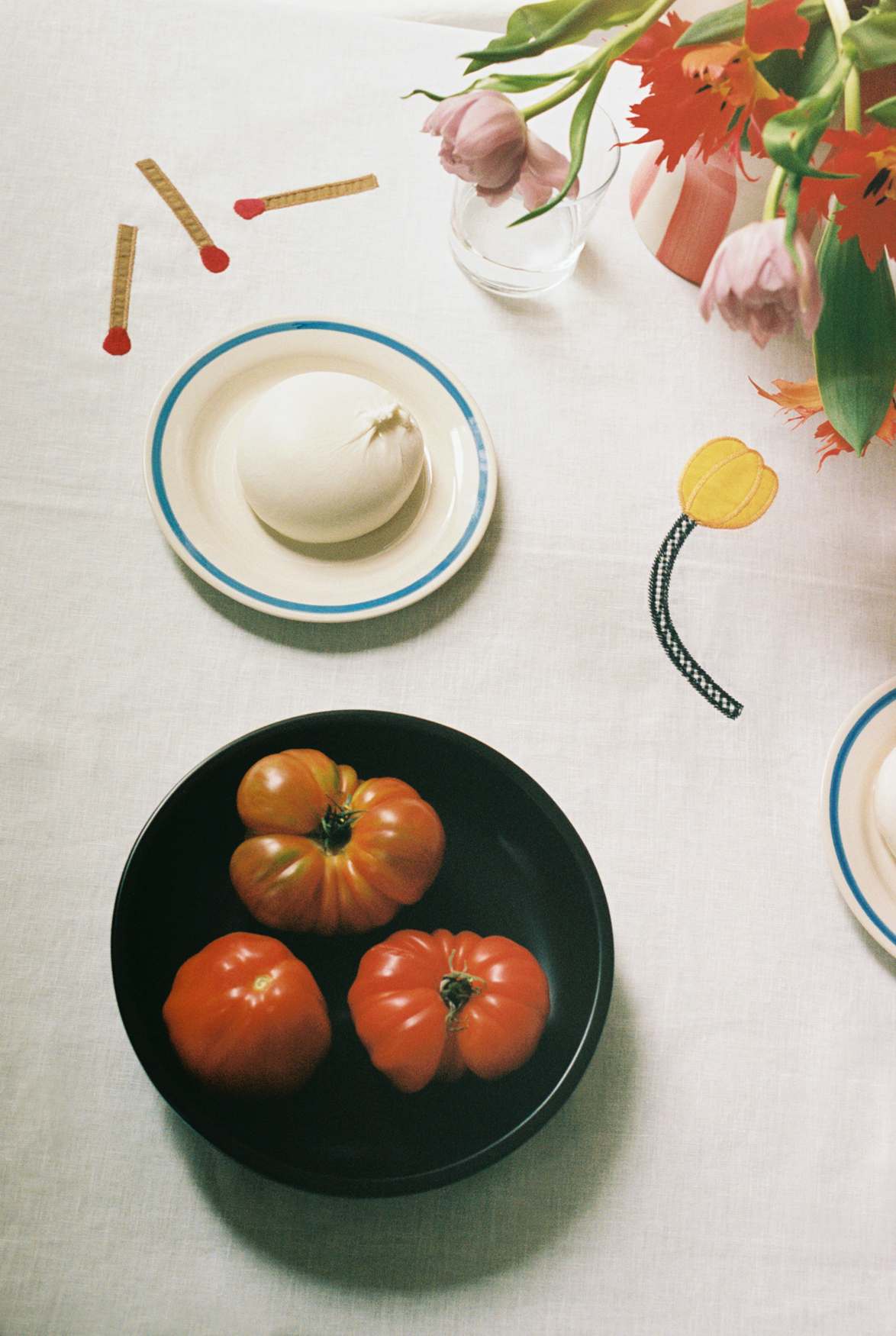 Sobremesa Tischdecke: Stillleben mit frischen Tomaten, Mozzarella und Blumen auf der weißen Tischdecke.