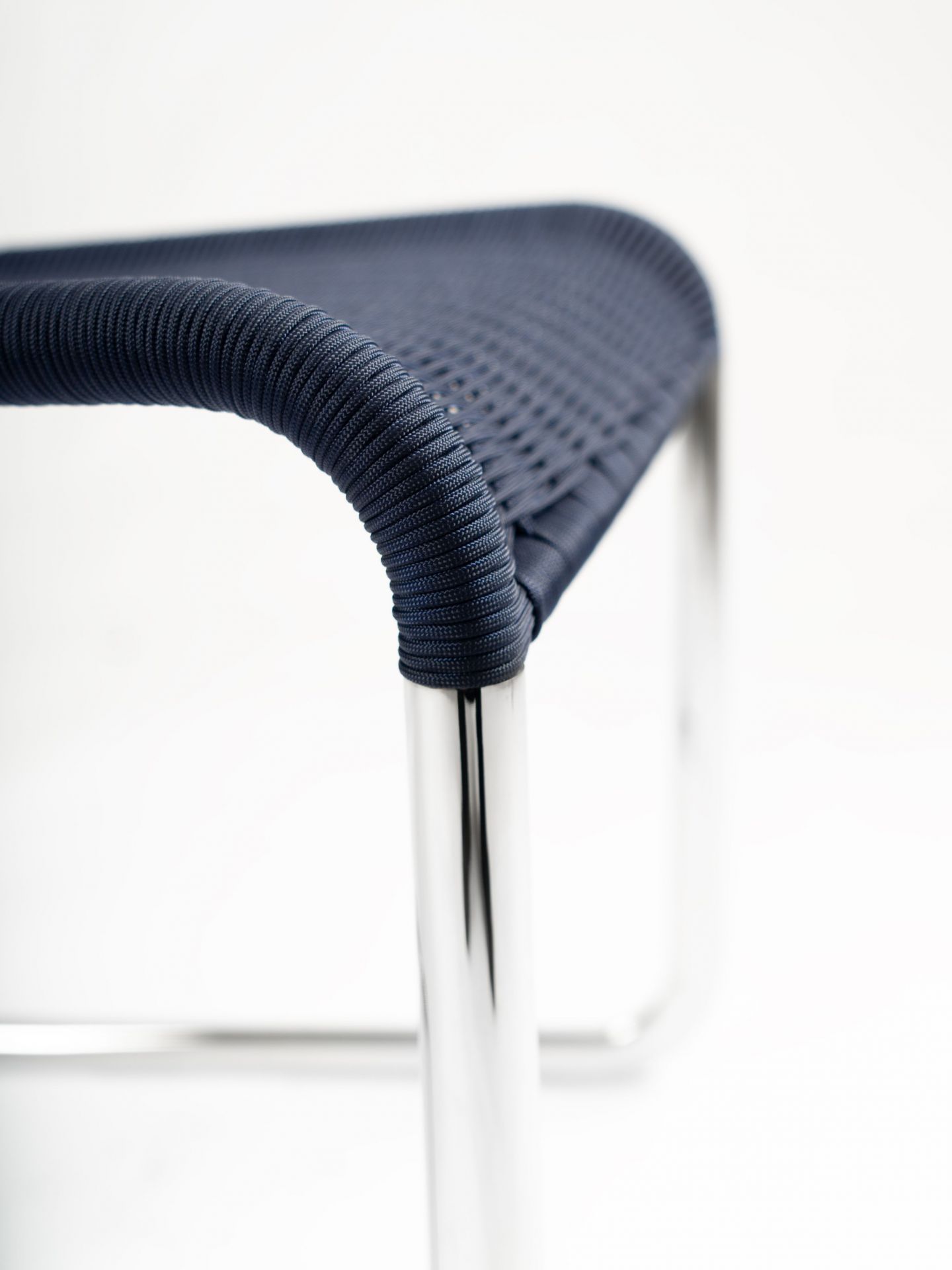 Detailaufnahme des B25 Kragstuhls von Tecta in Dunkelblau mit verchromtem Stahlrohrgestell. Designklassiker für modernes Wohnen.