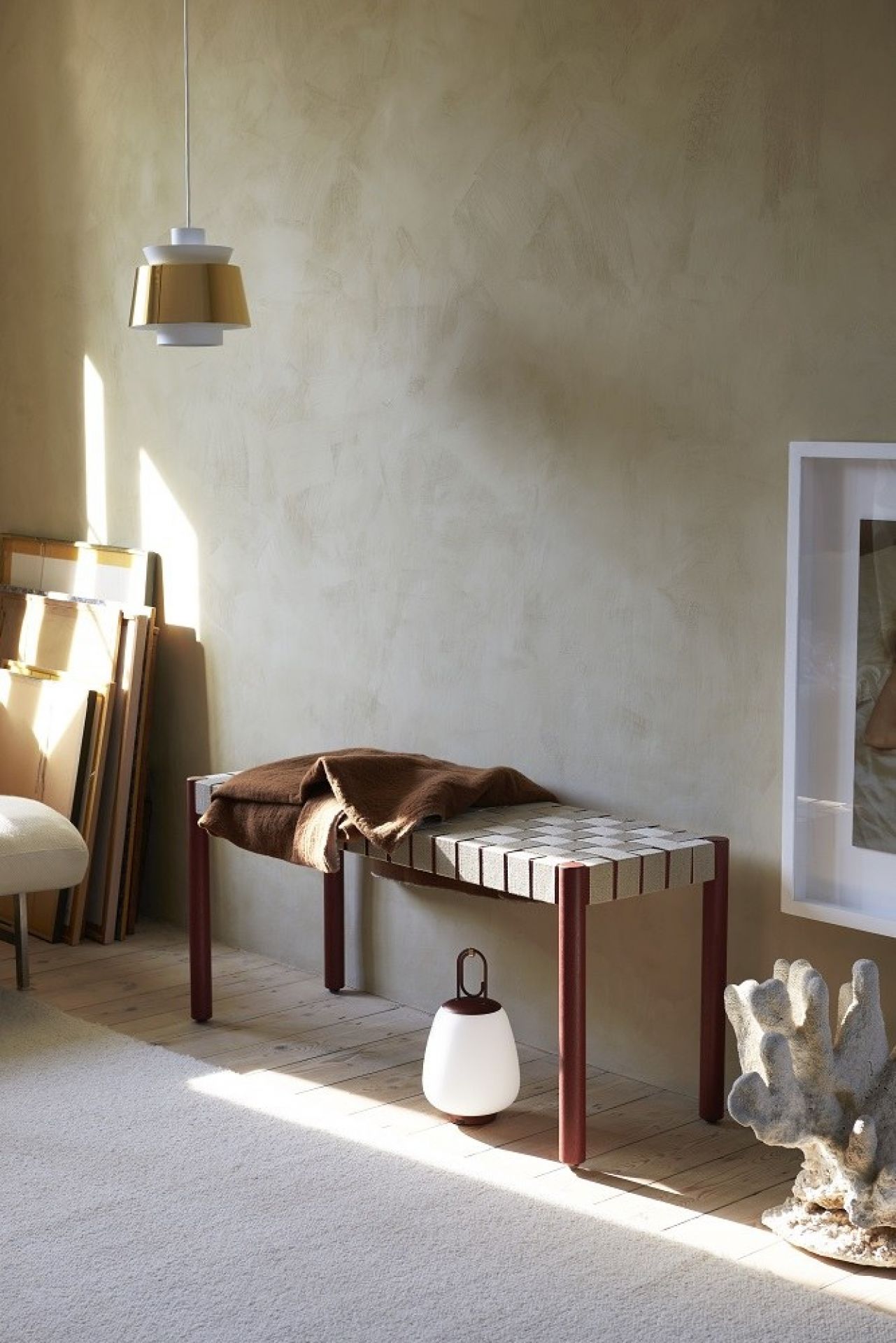 AndTradition Betty TK4 Bank mit brauner Decke in einem hellen Raum. Designermöbel für Wohnzimmer.