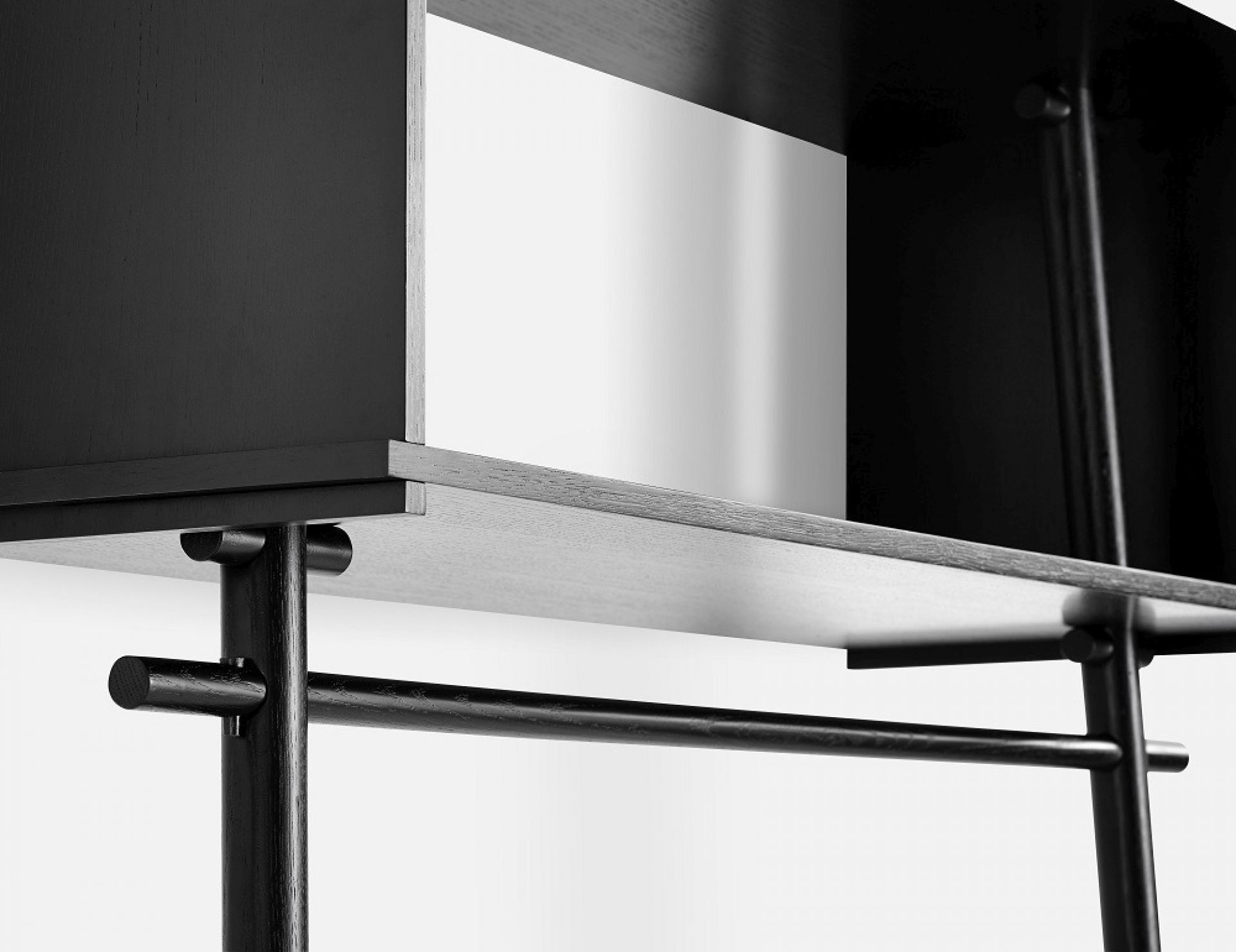 Detailaufnahme der schwarzen Töjbox Anlehngarderobe von Woud, gefertigt aus Eiche, mit minimalistischem Design und integrierter Kleiderstange.