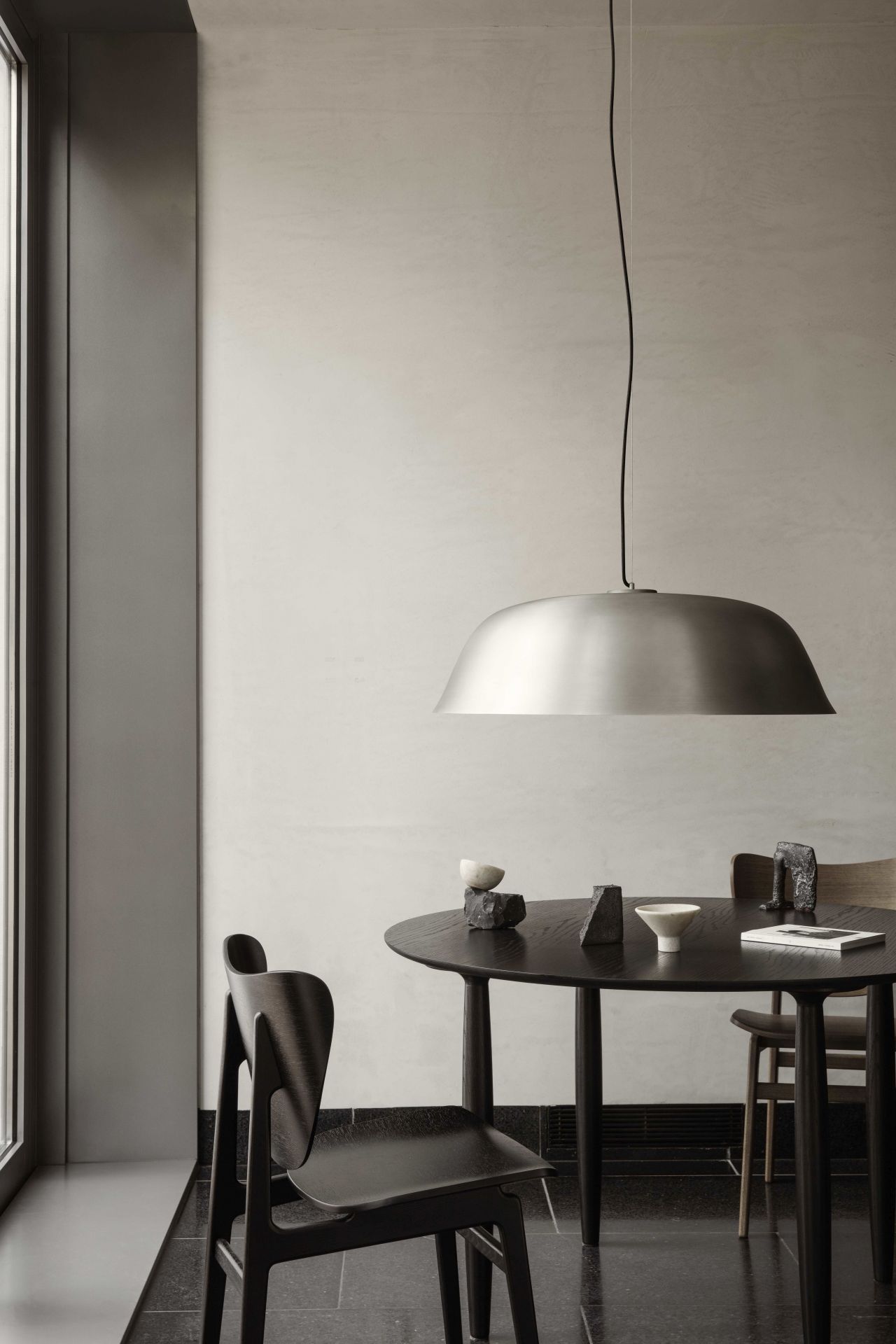 Oku Esstisch rund Eiche hell geräuchert von Norr11 mit Stühlen und Pendelleuchte in minimalistischem Interieur.