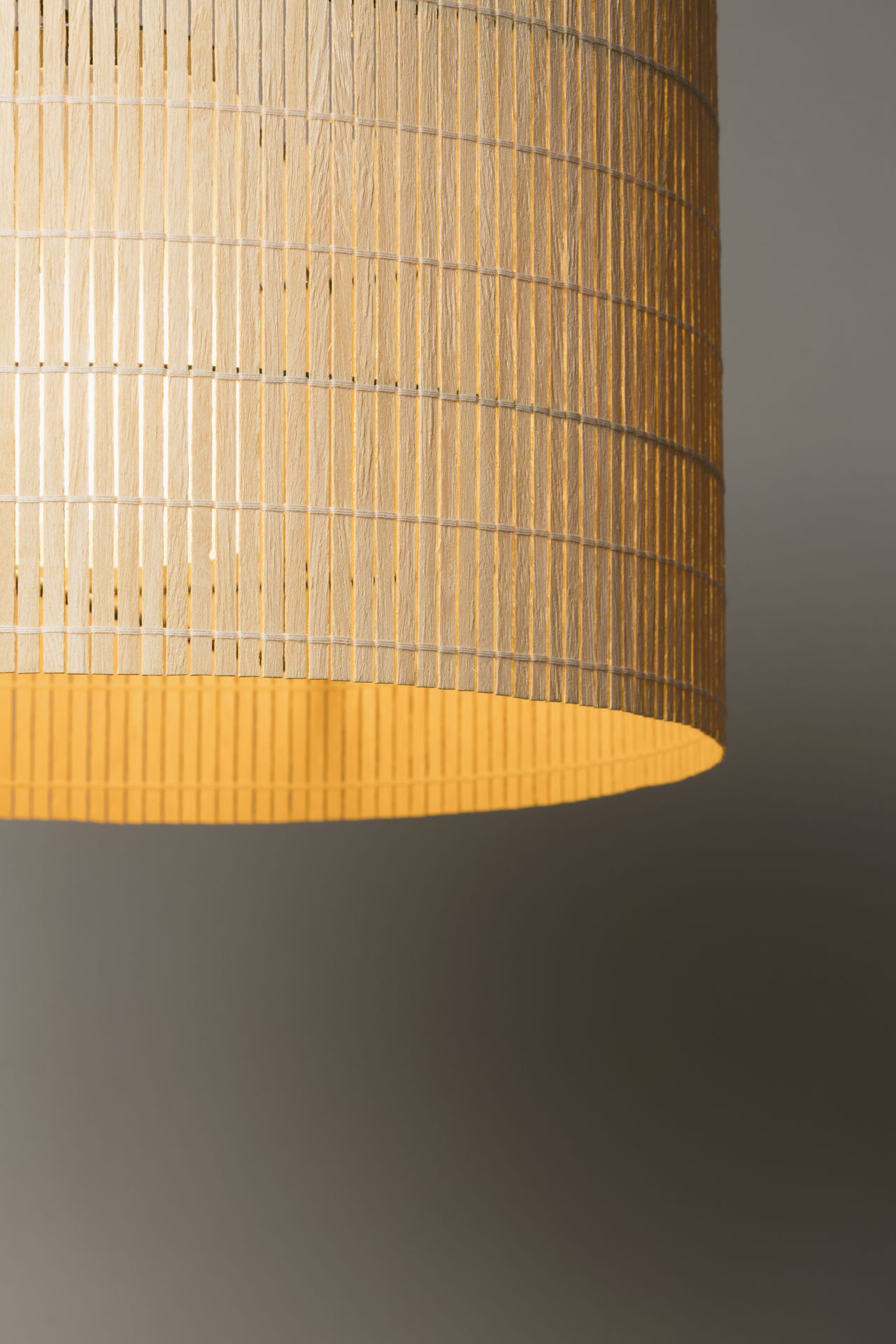 Nagoya Pendelleuchte von Santa & Cole mit zylindrischem Lampenschirm aus Holzfurnier und warmem Licht.