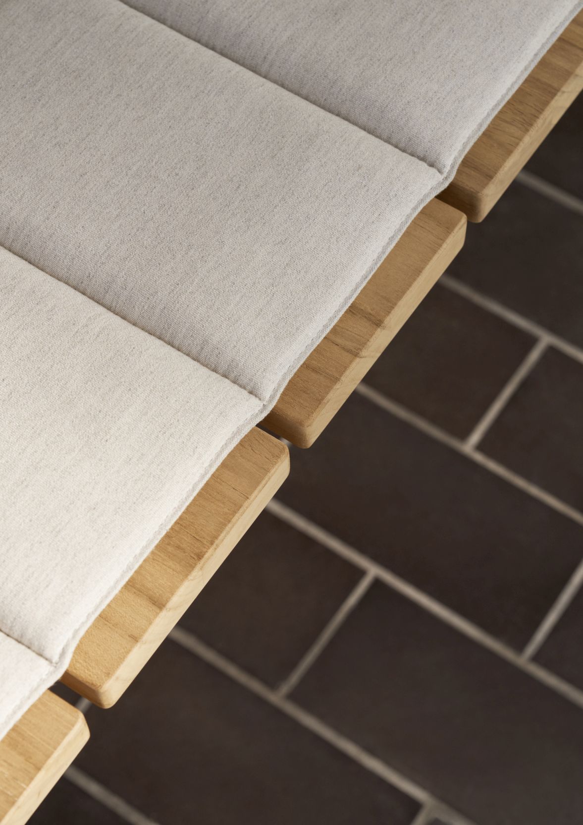 Detailaufnahme: CU GL101 Timbur Kissen für Carl Hansen Bank, hellgrauer Outdoor-Stoff auf Holz.