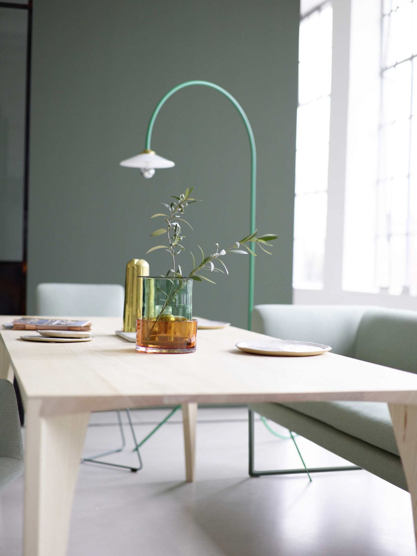 Delta Tisch von Cor, Esstisch aus hellem Holz mit Vasen und Geschirr dekoriert.