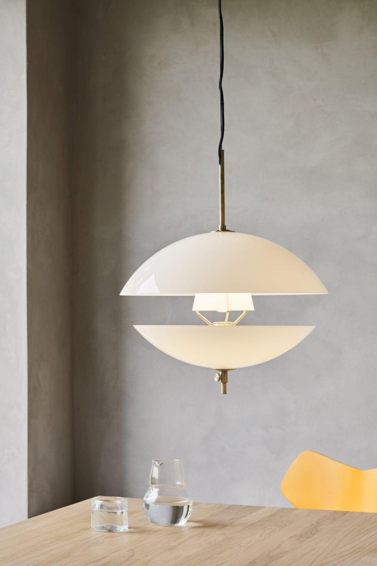Nahaufnahme der Fritz Hansen Clam Pendelleuchte 55 cm, weiße Designlampe mit Messingdetails.