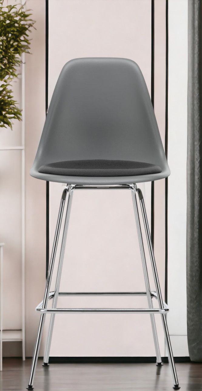 Grauer Eames Plastic Bar Stool Barhocker von Vitra mit Sitzpolster und verchromtem Gestell.