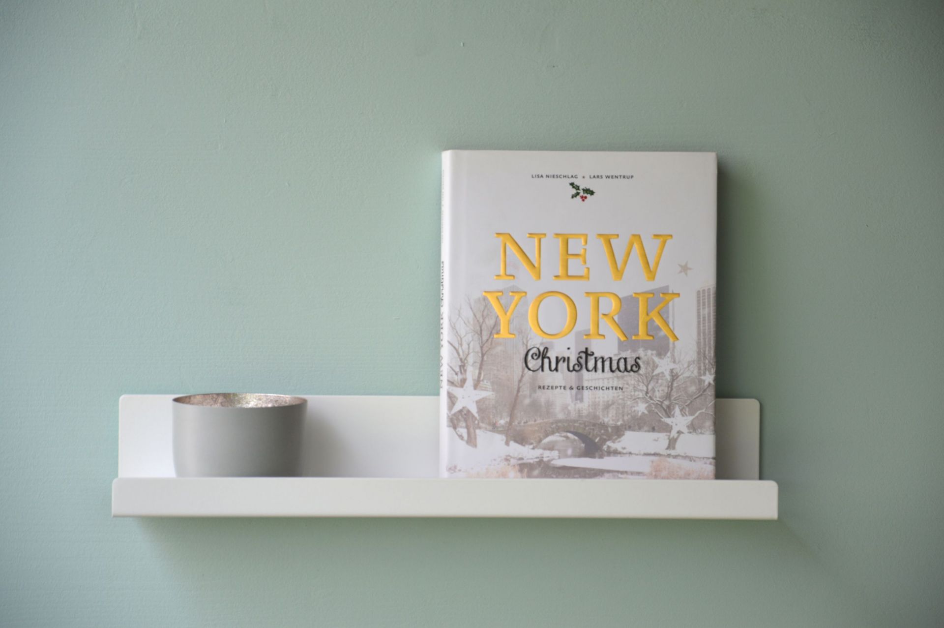 Schwarzes Jill Wandregal von Jan Kurtz (80 cm) an Wand mit Buch und Deko.