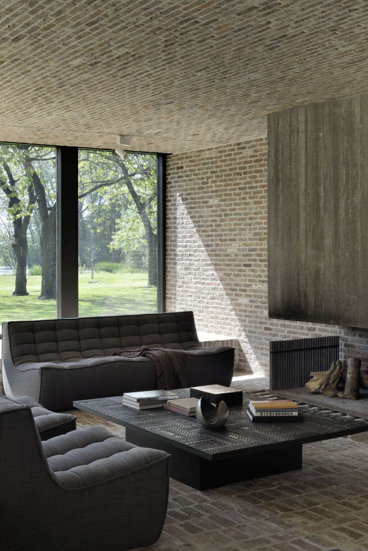 Schwarzer Ethnicraft Tabwa Couchtisch aus Teakholz im Wohnzimmer mit Sofa und Büchern.