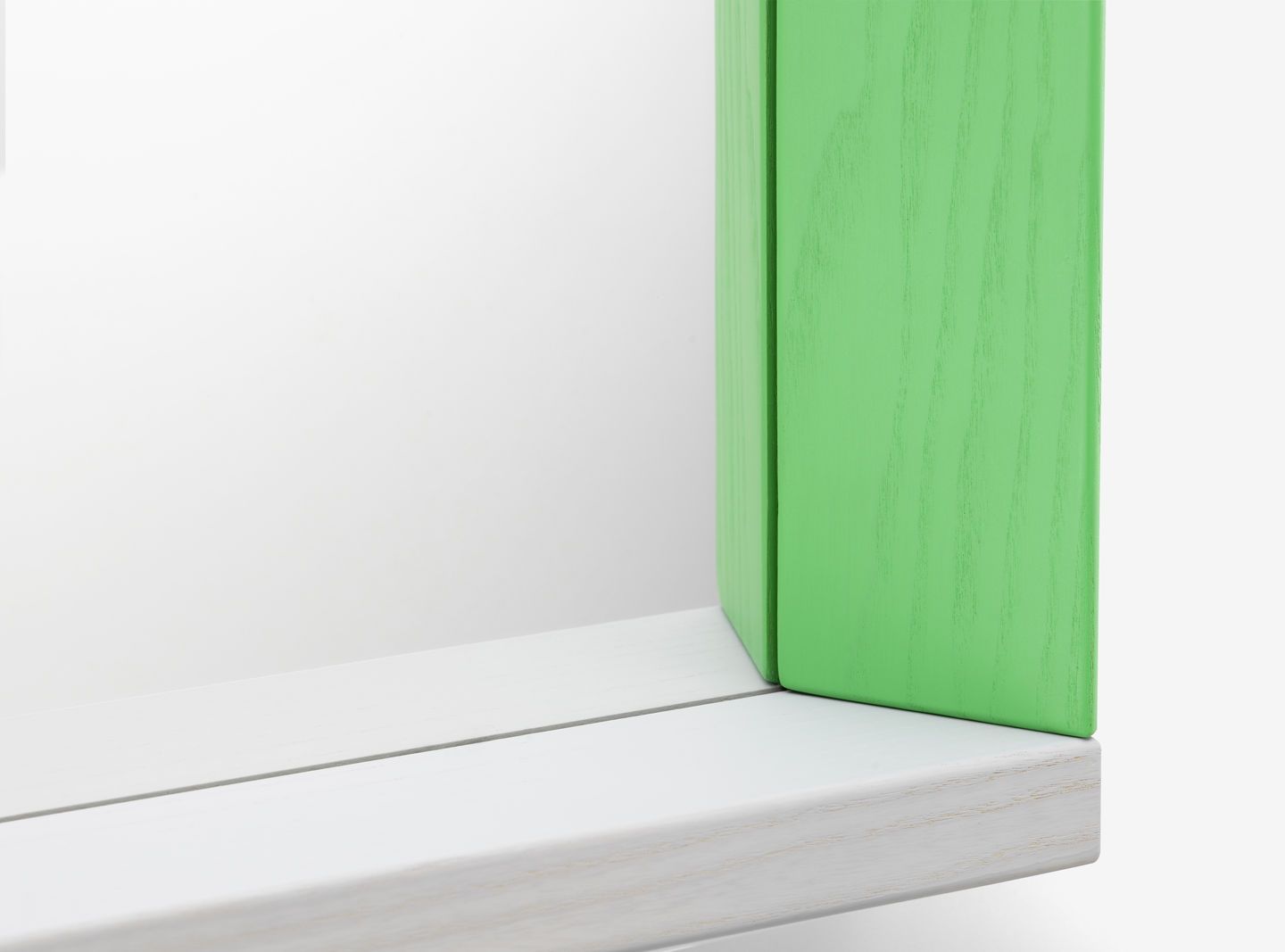 Detailaufnahme eines Colour Frame Spiegels von Vitra mit grünem Rahmen und weißer Spiegelfläche.